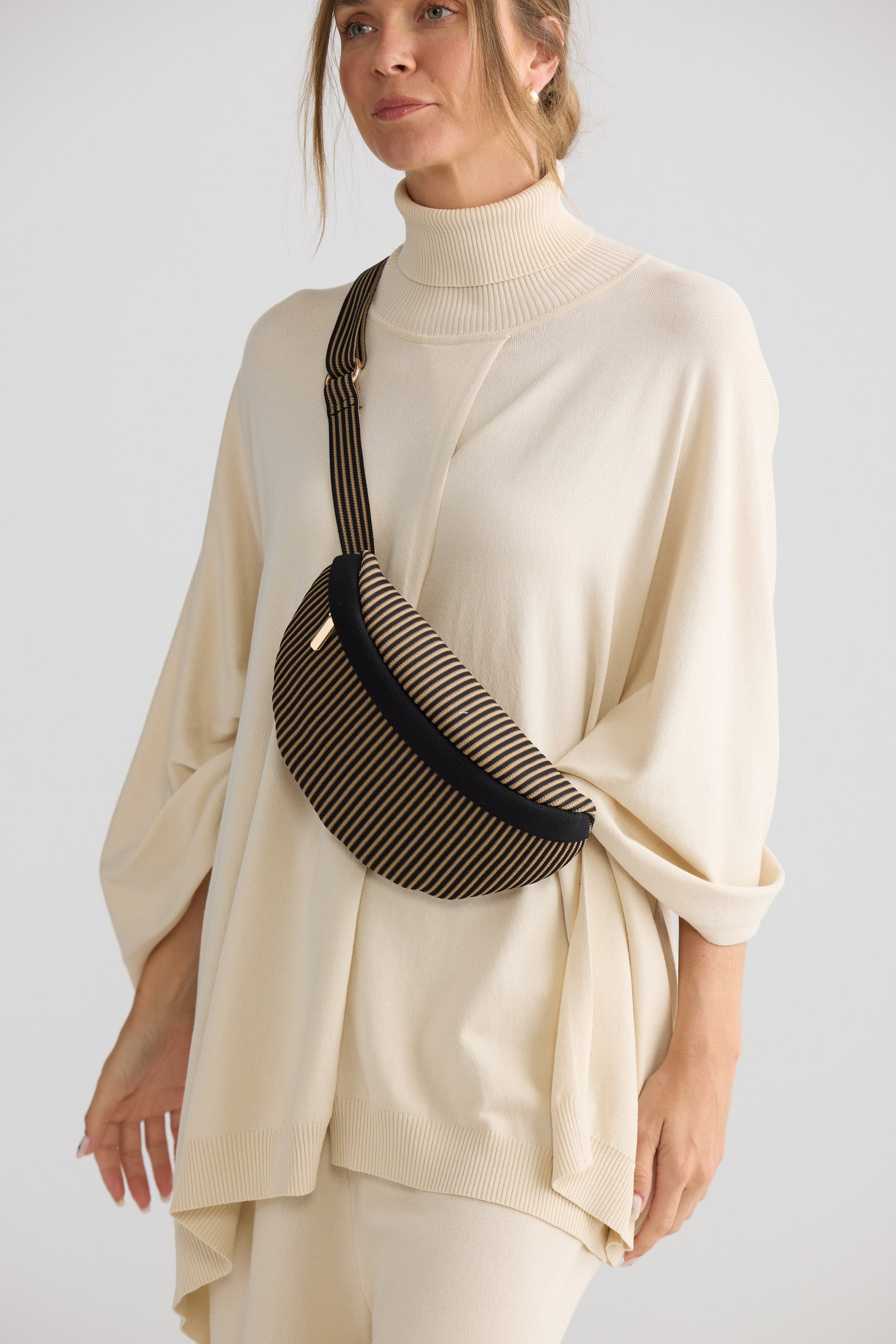 Delphi Bumbag - Black bum bag in black with stripe detailing, styled view on white background