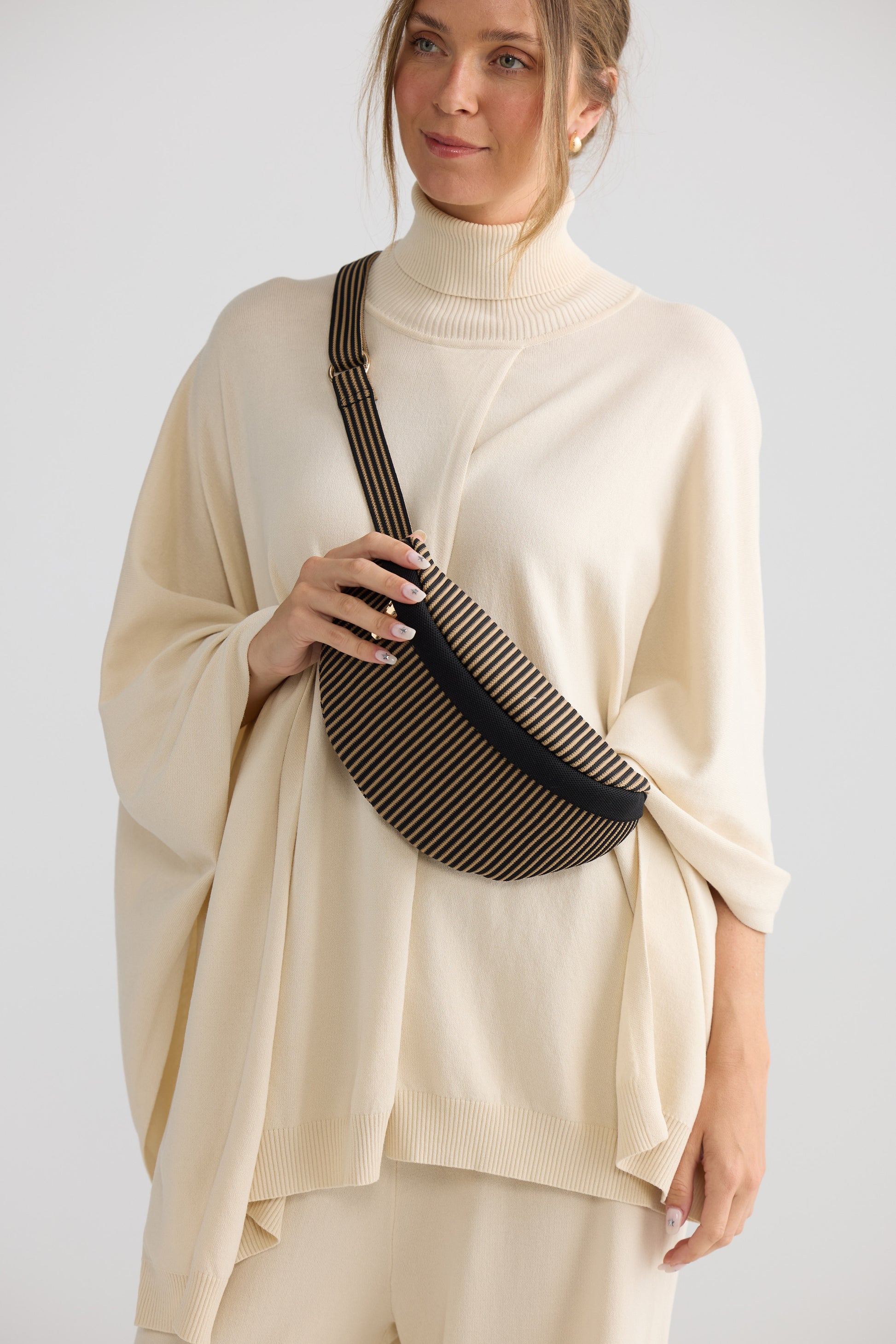 Delphi Bumbag - Black bum bag in black with stripe detailing, side view on white background