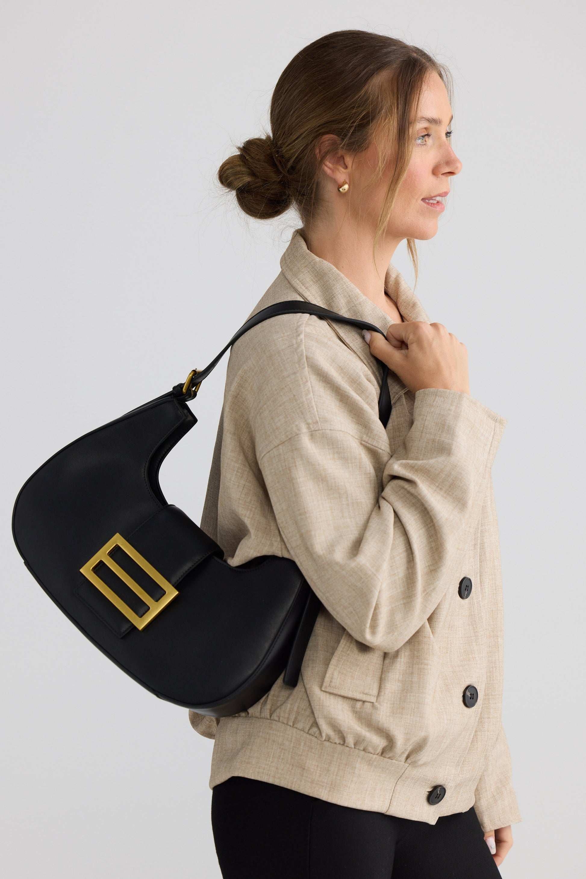 Virginia Handbag - Black handbag in black with gold-tone hardware, side view on white background
