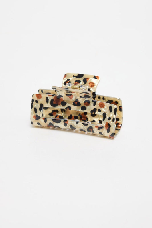 Zali Hair Claw in cheetah-print acetate, shown at an angle highlighting the rectangular shape and gold spring hinge