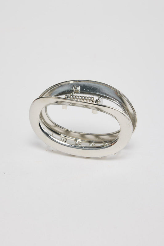 Noosa Hair Claw in silver - angled view of the sleek oval metal hair claw showing the spring hinge