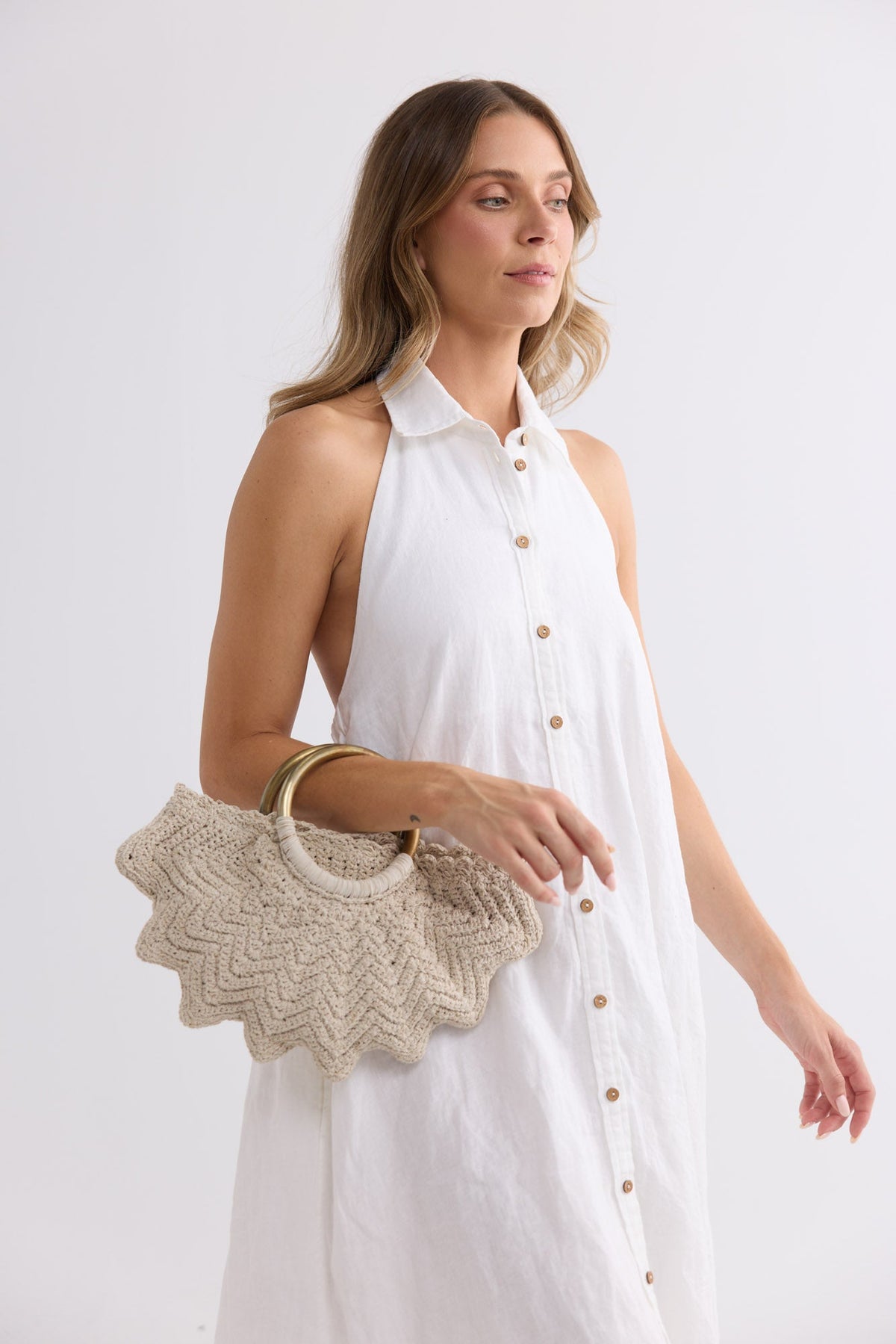 Santana Bag in off white worn on the forearm, styled with a white sleeveless dress