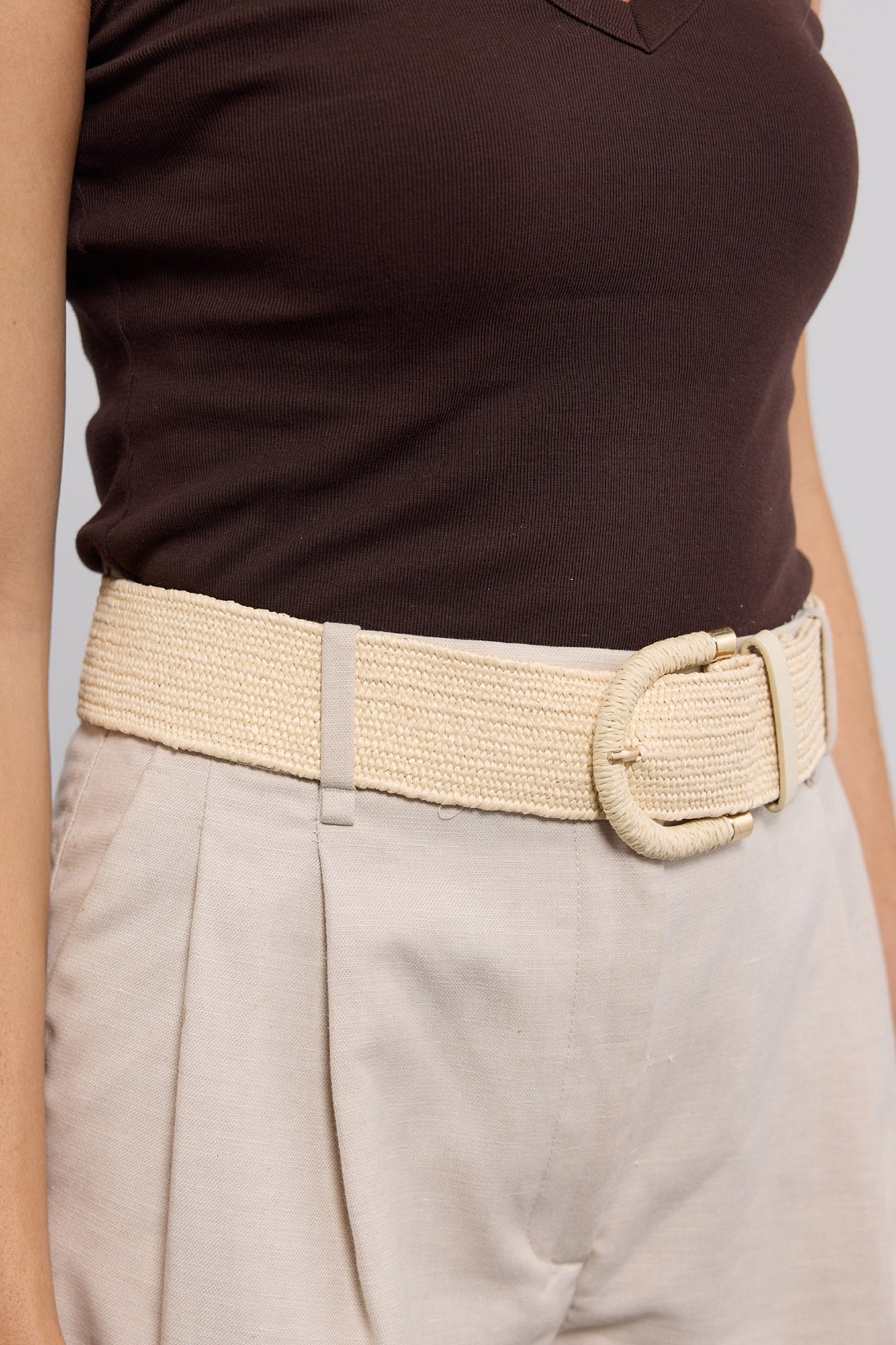 Reid Belt in beige worn cinched at the waist over a brown tank and cream trousers