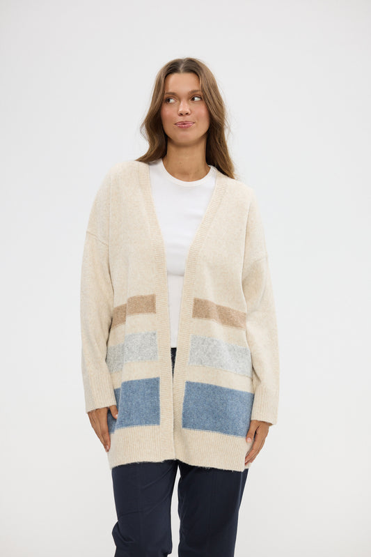 Woman wearing a beige cardigan with color-blocked pockets on a white background