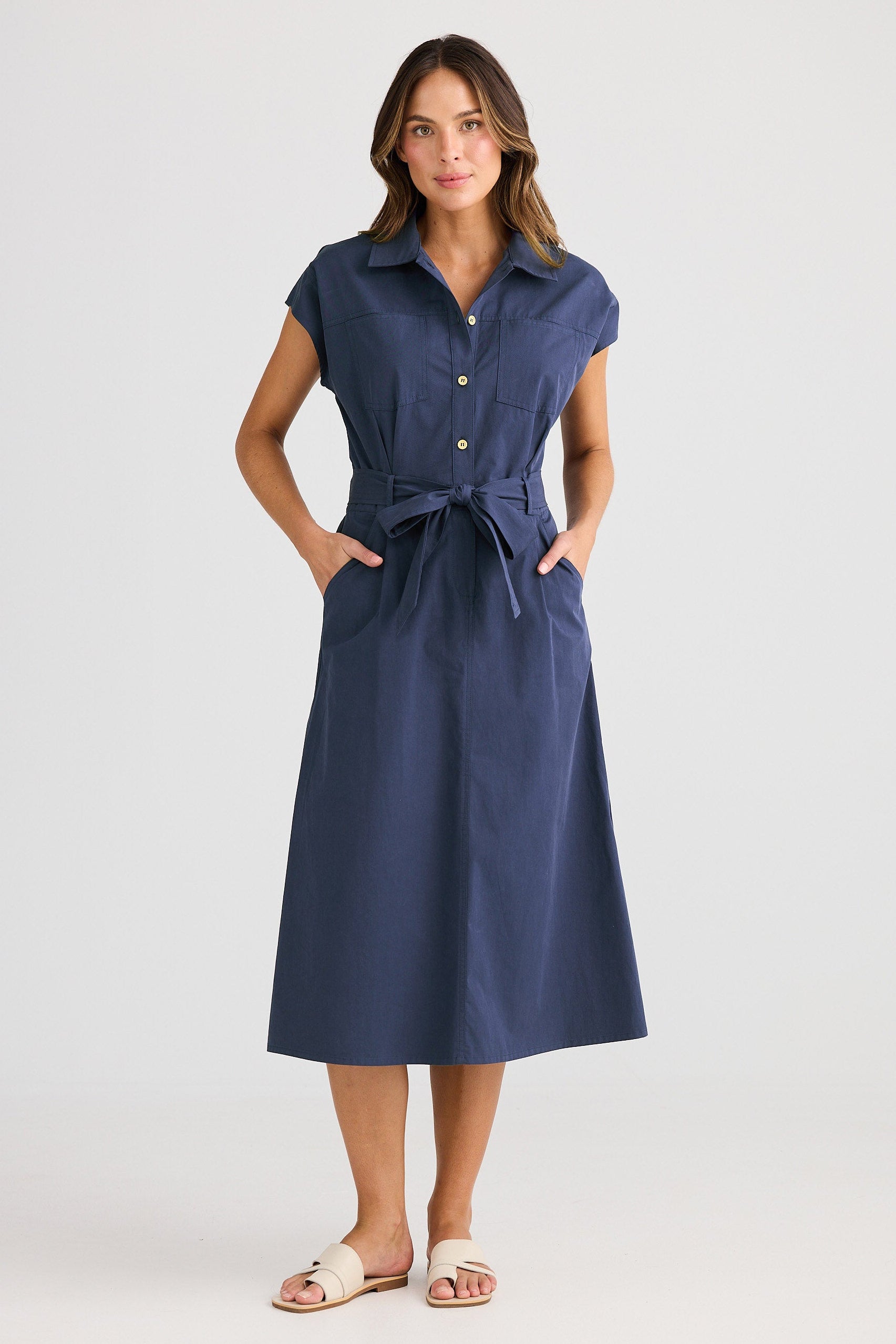 Woman wearing a blue dress with a belt on a white background