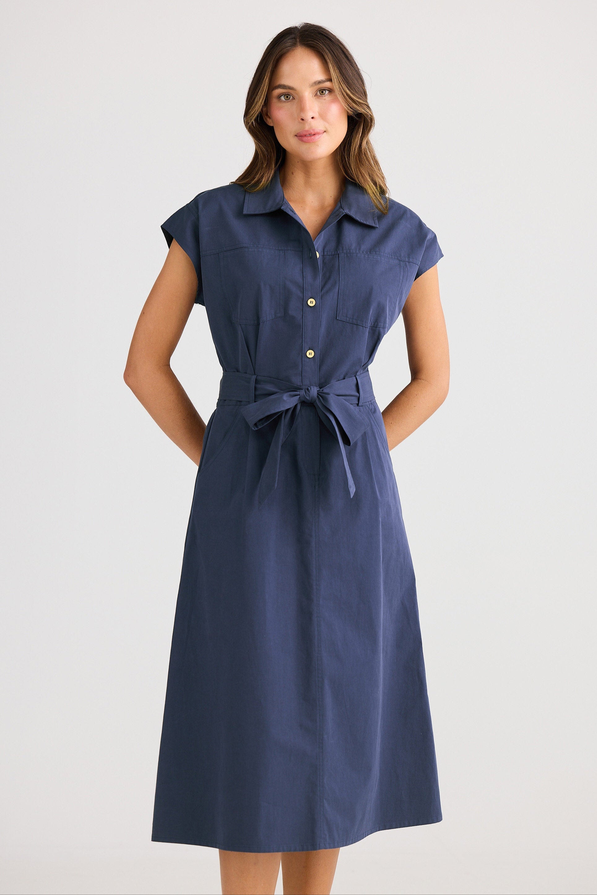 Woman wearing a blue dress with a belt on a white background