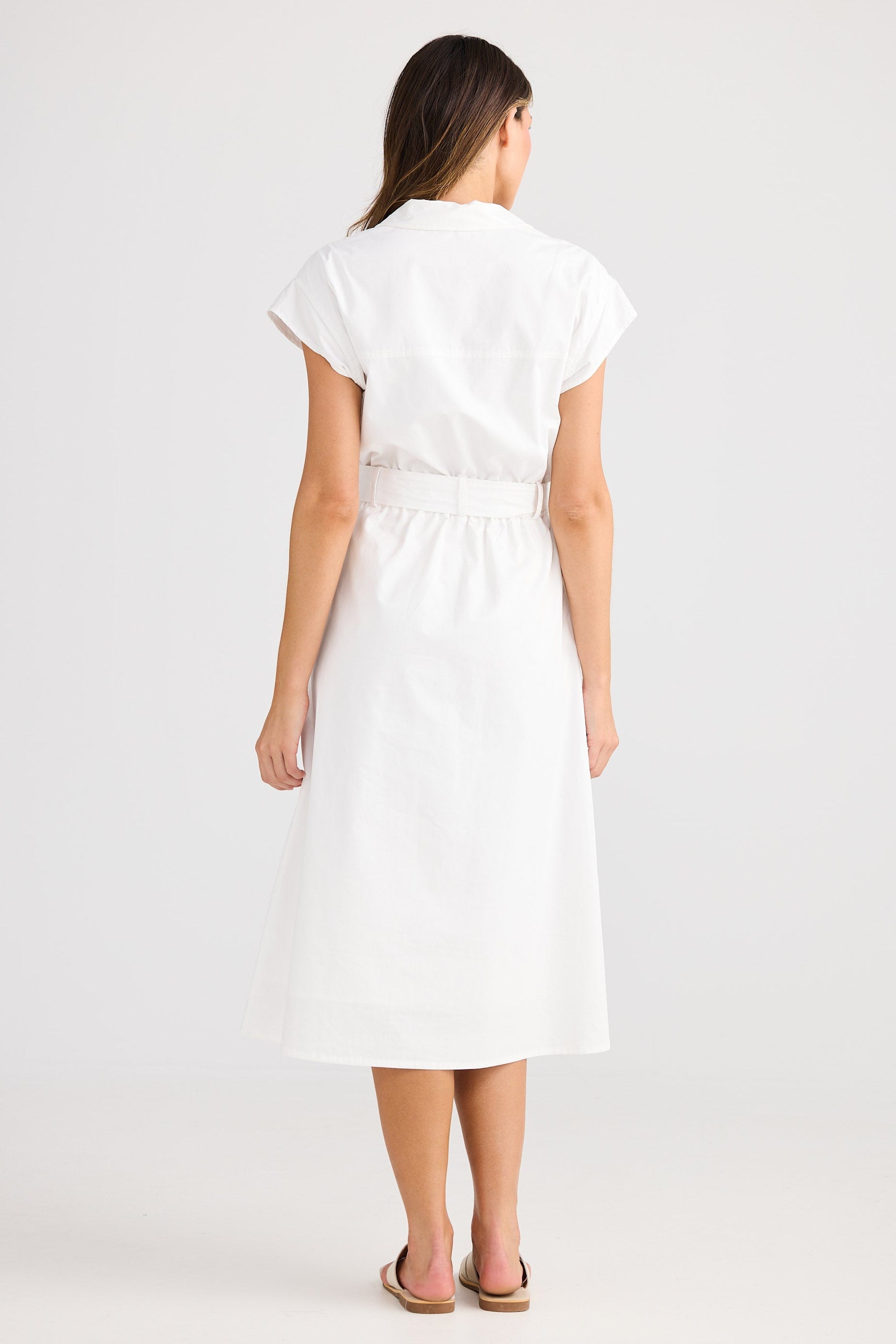 Woman wearing a white dress on a plain background