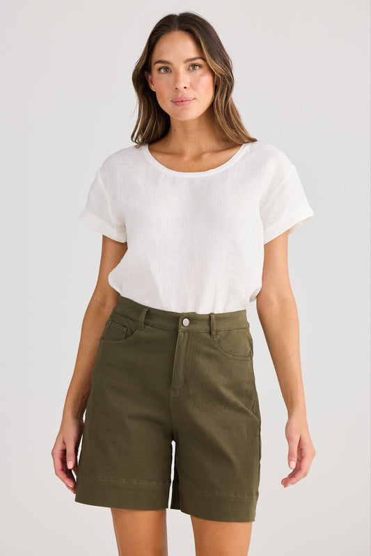 Woman wearing a white t-shirt and green shorts on a plain background