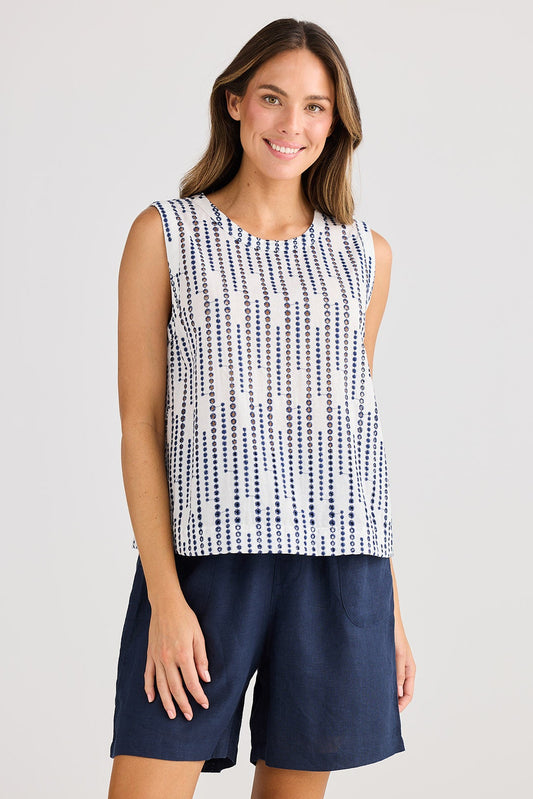 Woman wearing a sleeveless top and shorts on a plain background