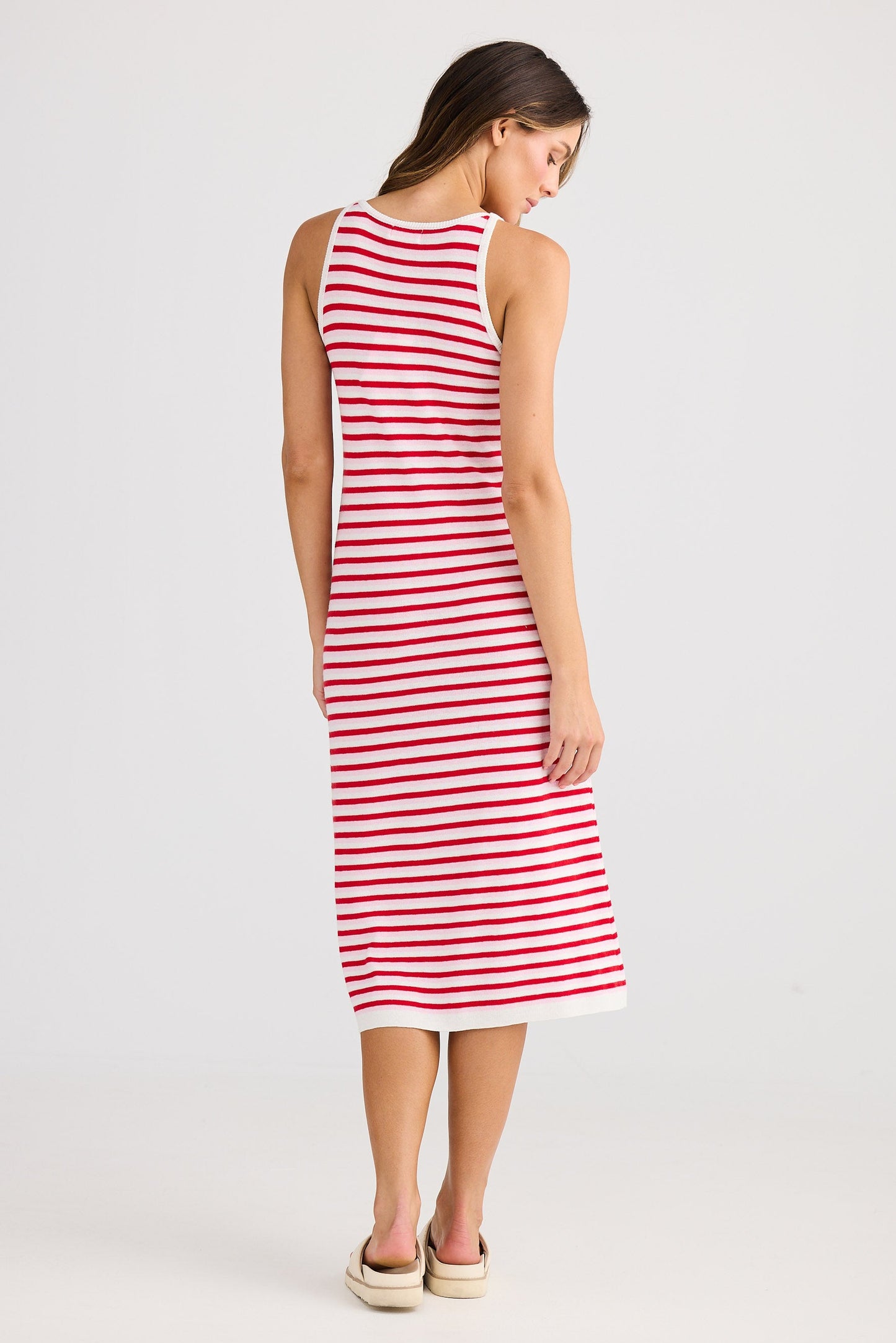 Woman wearing a red and white striped dress on a plain background