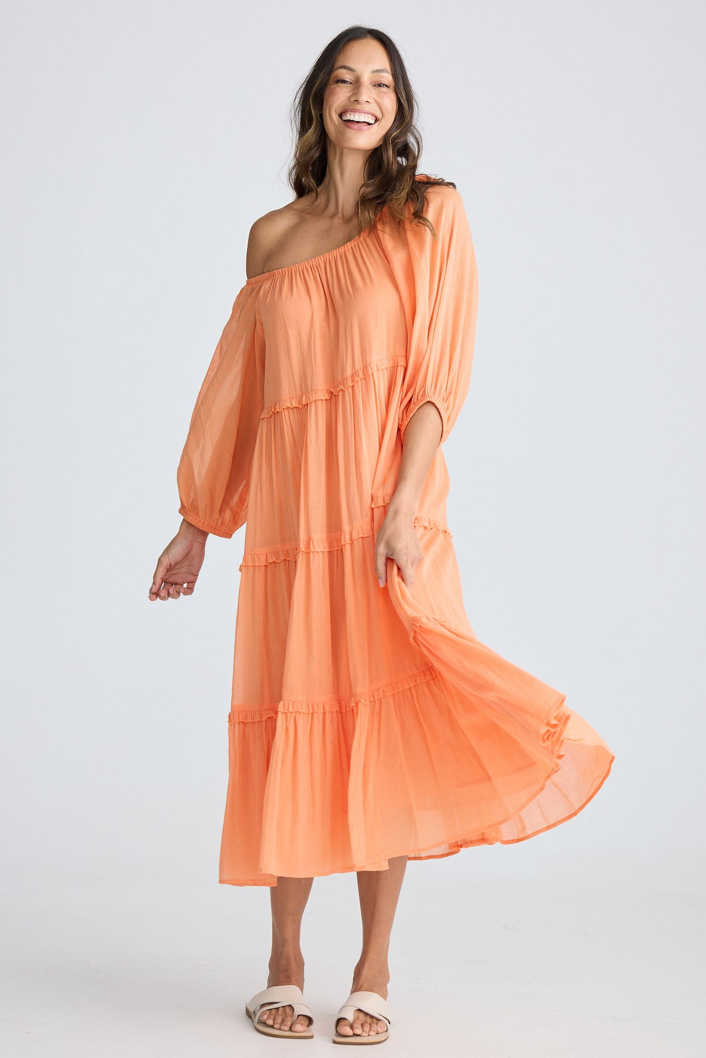Woman wearing an orange off-shoulder dress on a white background