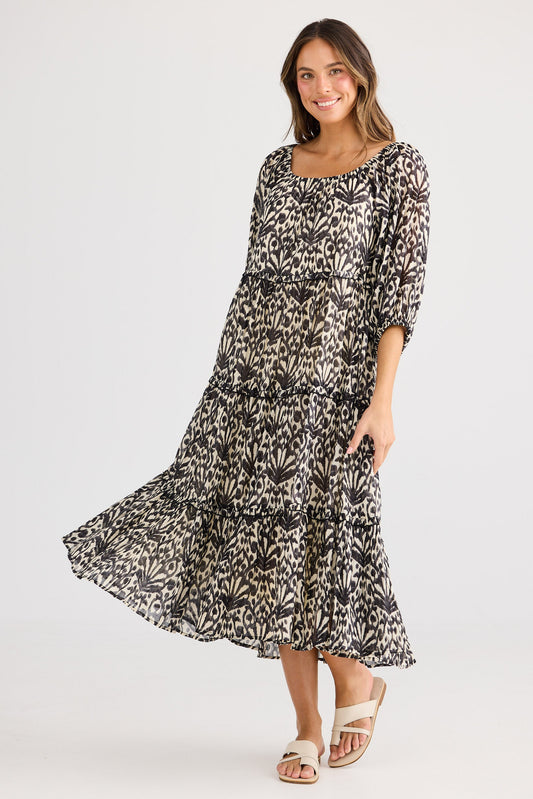 Woman wearing a patterned dress on a white background