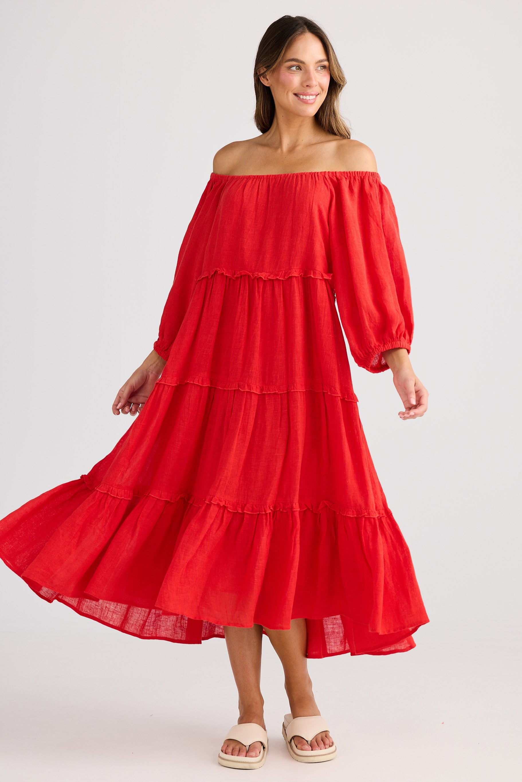 Woman wearing a red off-shoulder dress on a white background