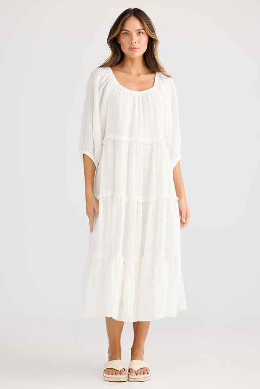 Woman wearing a white dress on a plain background