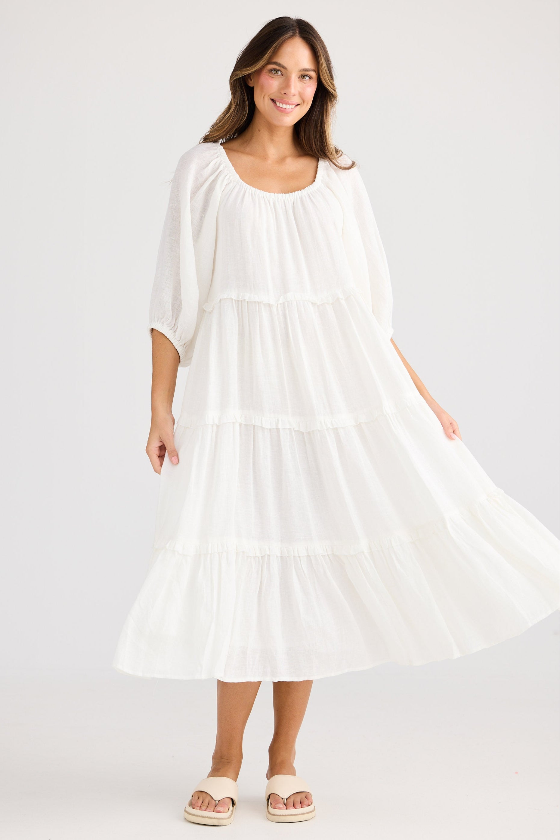 Woman wearing a white dress on a plain background