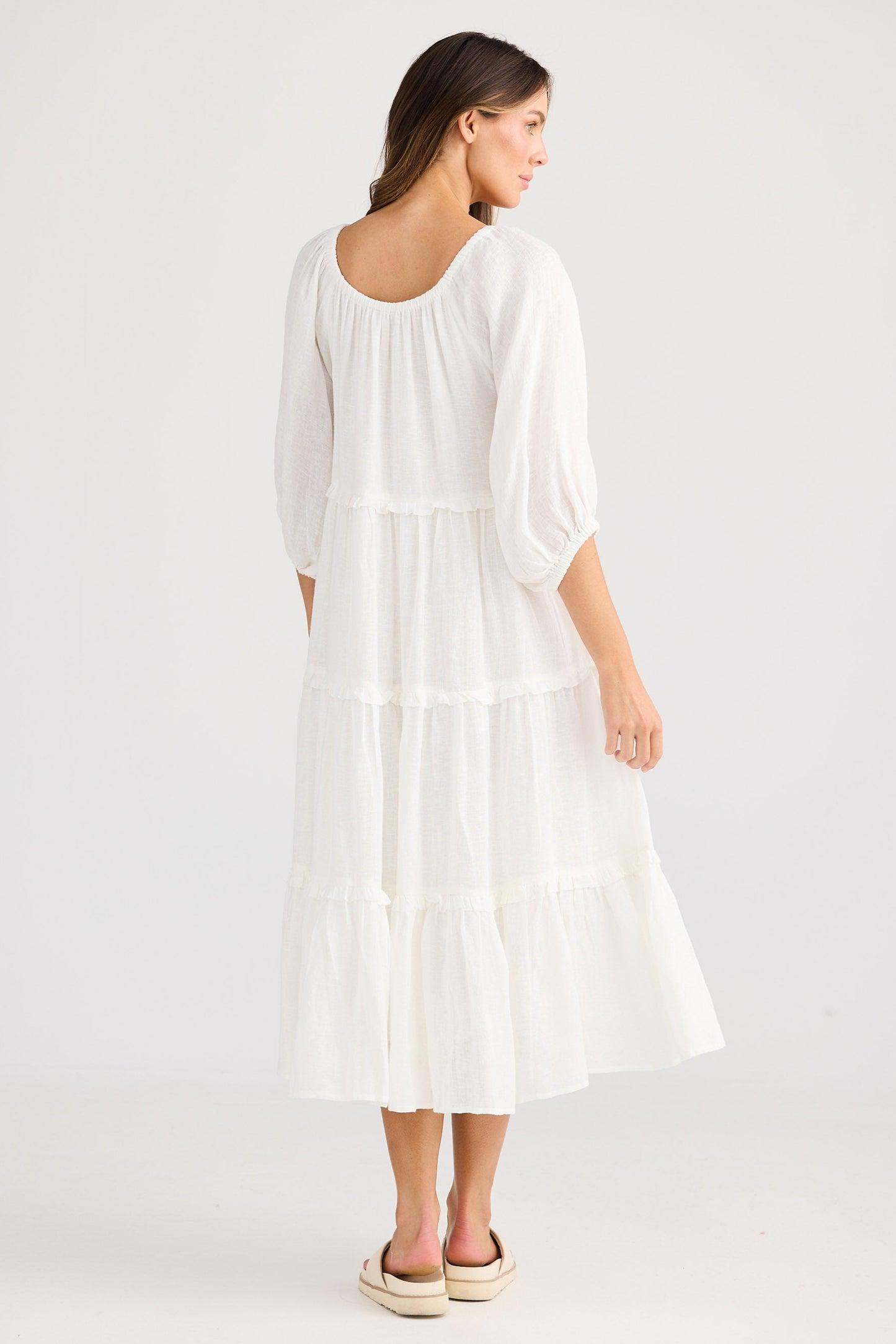 Woman wearing a white dress on a plain background