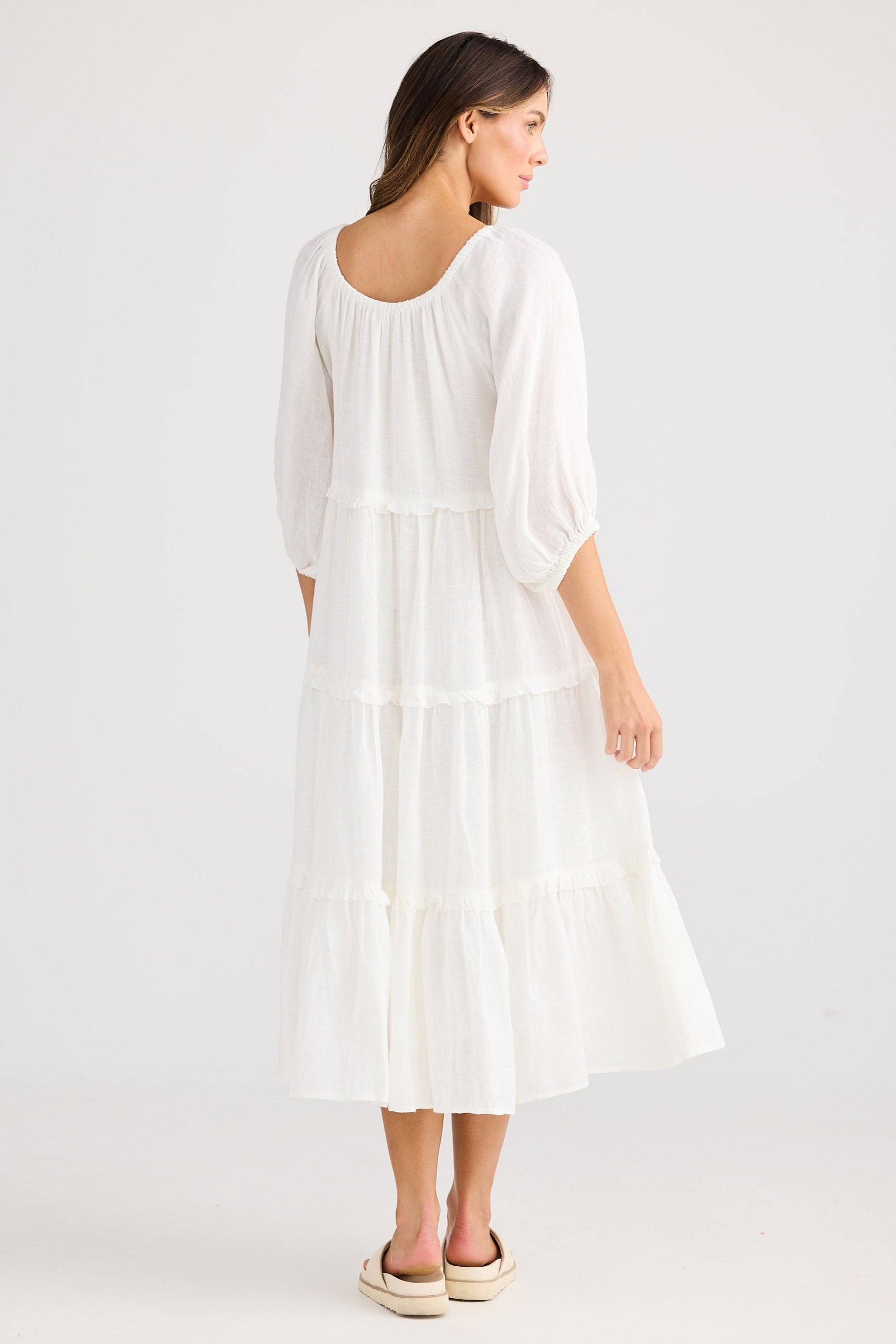 Woman wearing a white dress on a plain background