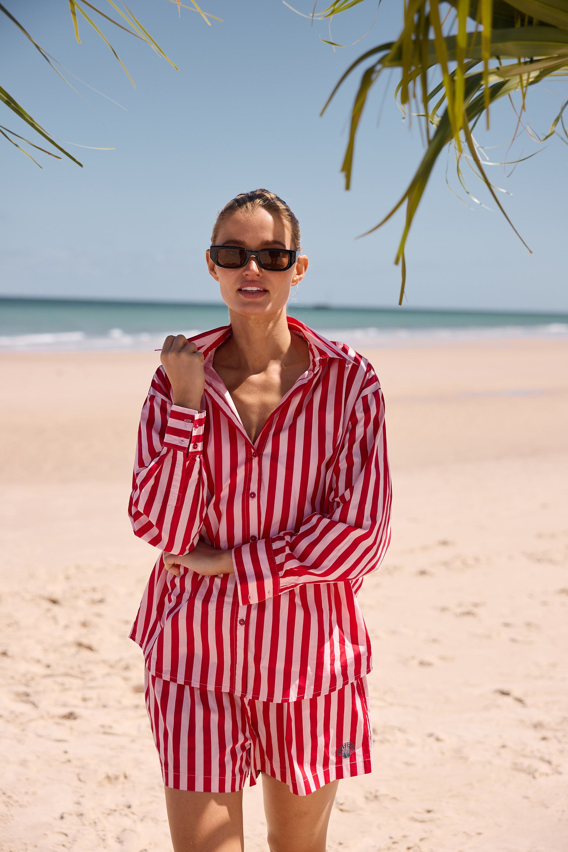 Woman in red and white striped outfit on a beach