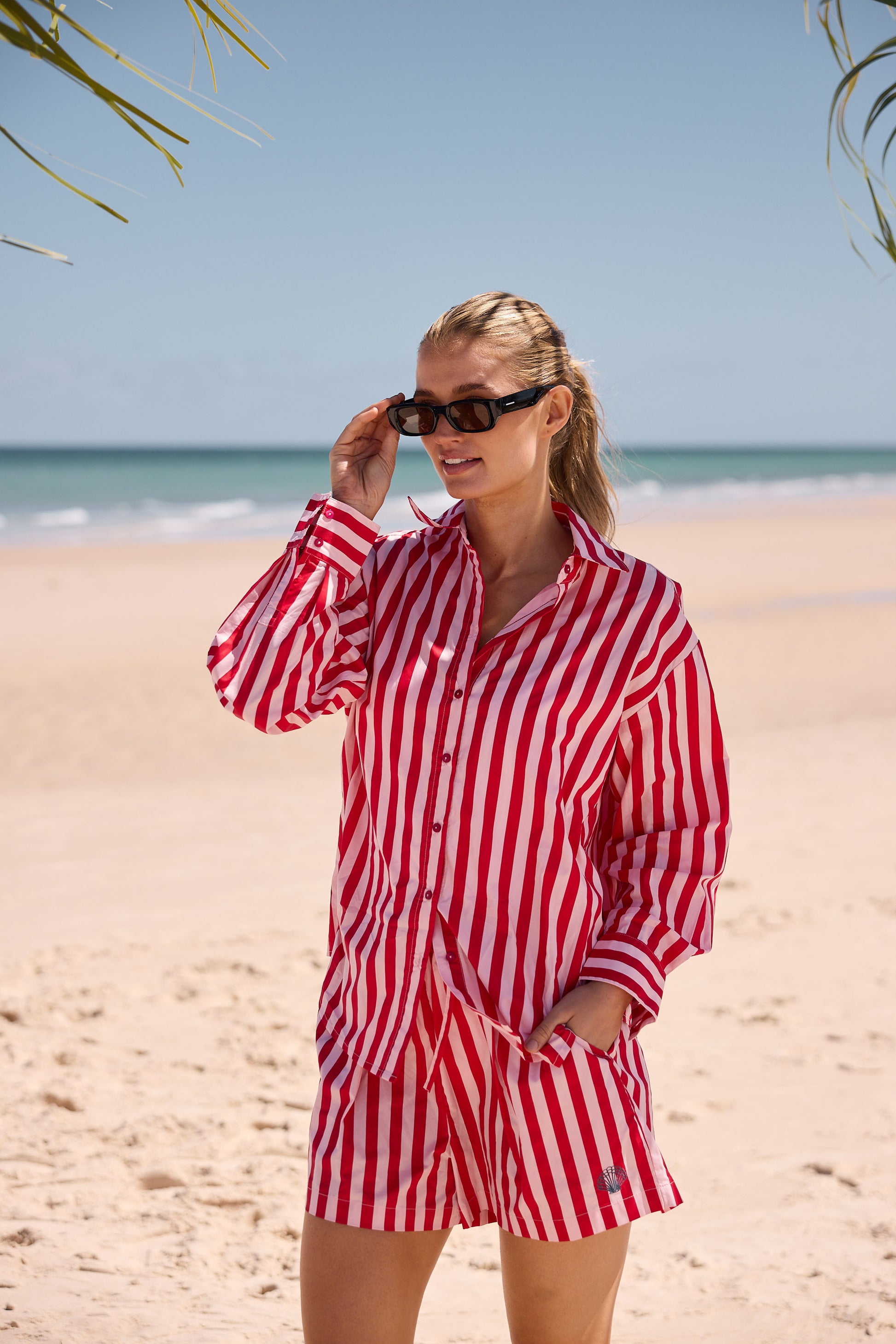 Woman in a red and white striped outfit on a beach