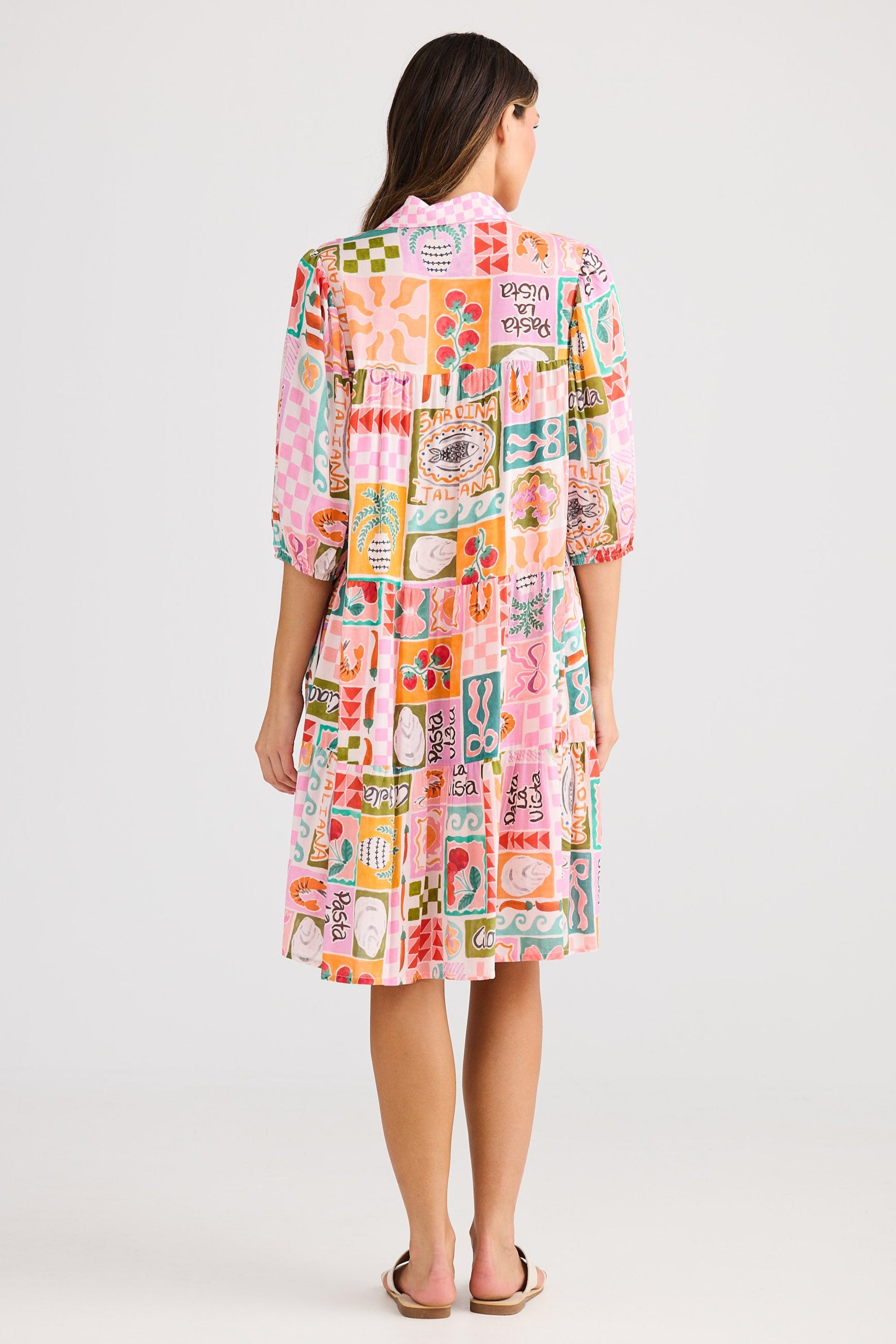 Woman wearing a colorful patterned dress on a white background