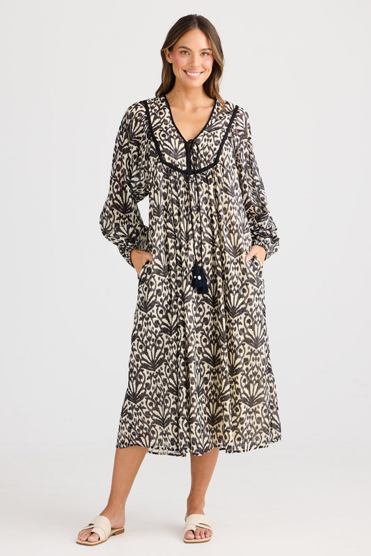 Woman wearing a patterned dress on a white background