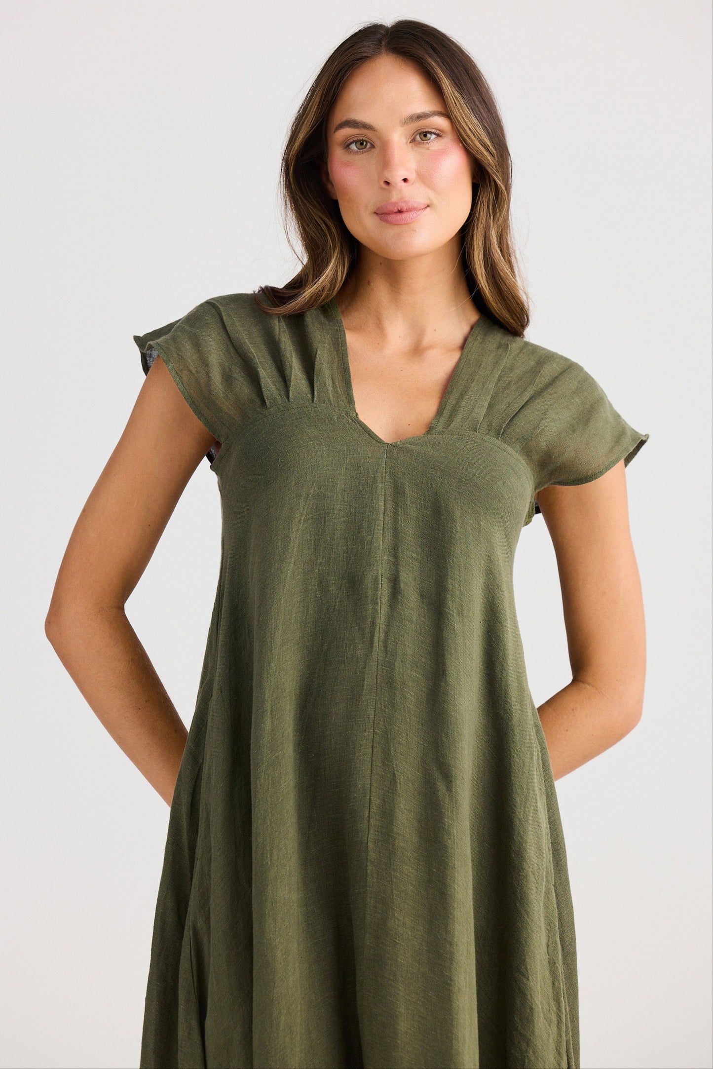 Woman wearing a green dress against a plain background