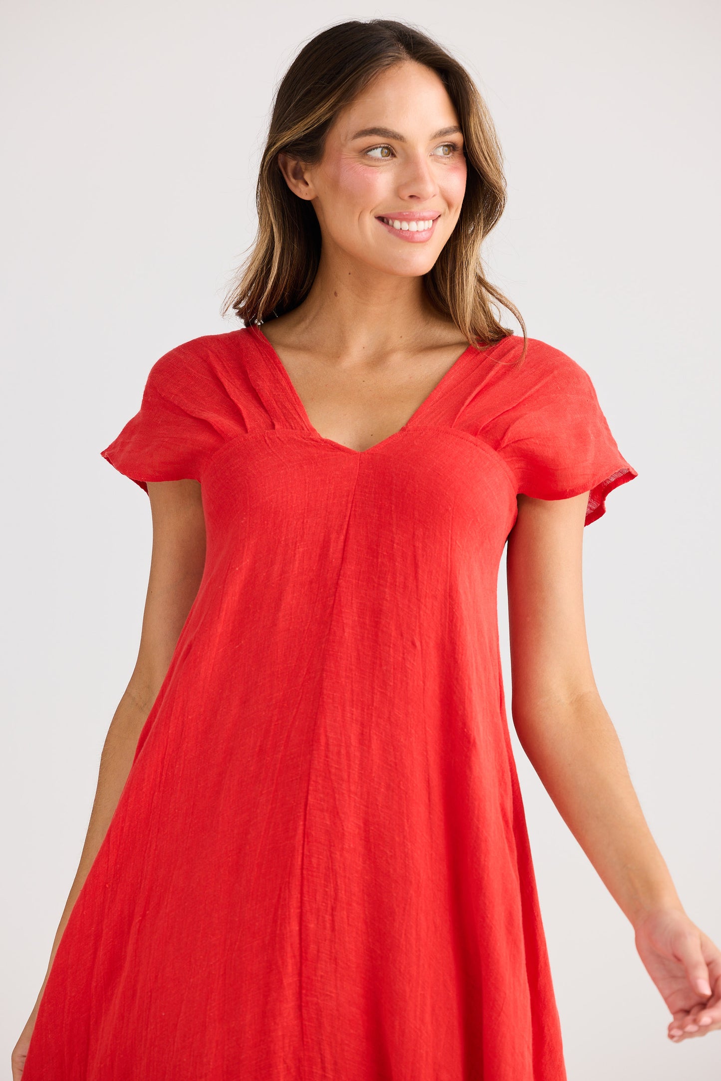 Woman wearing a red dress against a plain background
