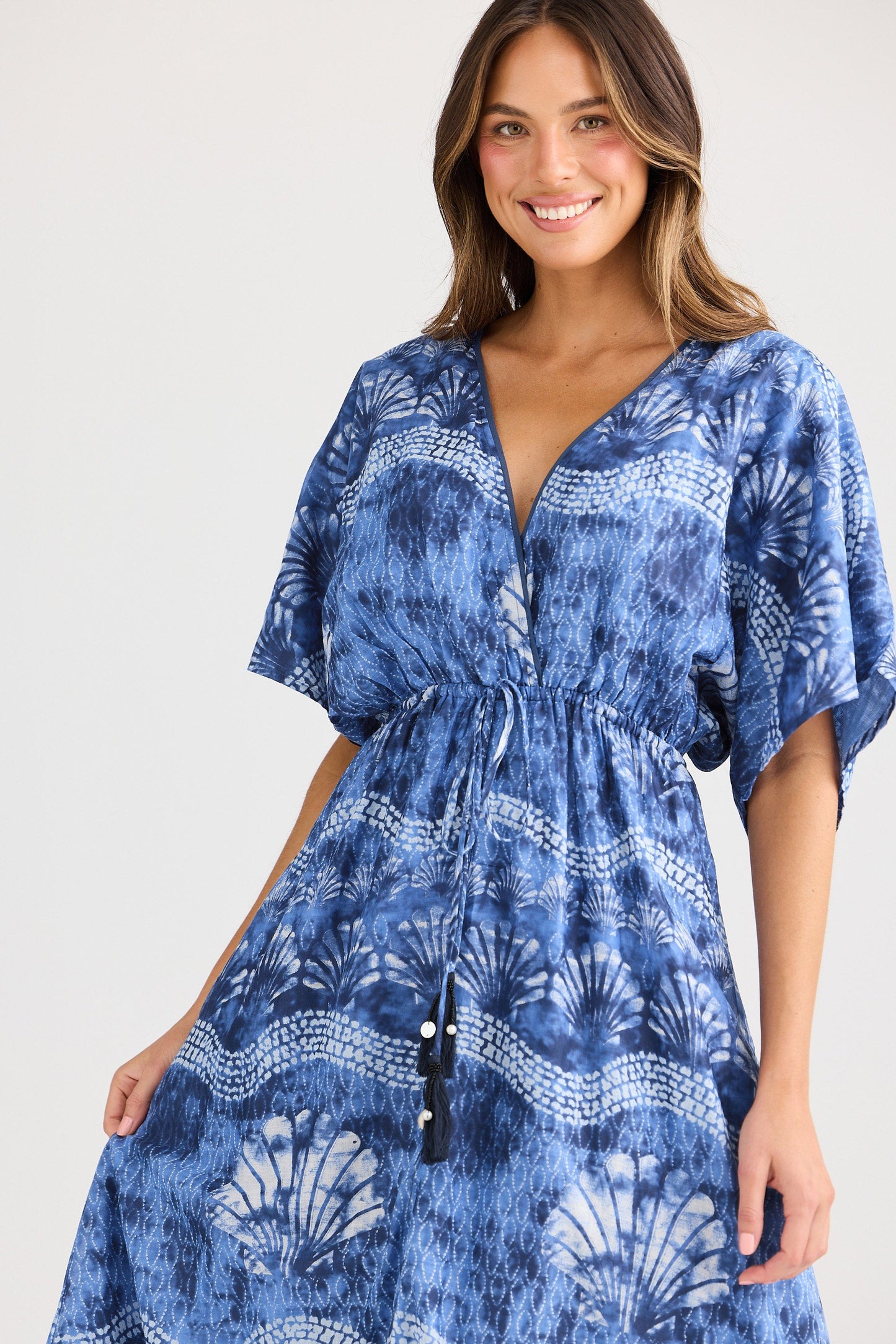 Woman wearing a blue patterned dress on a white background