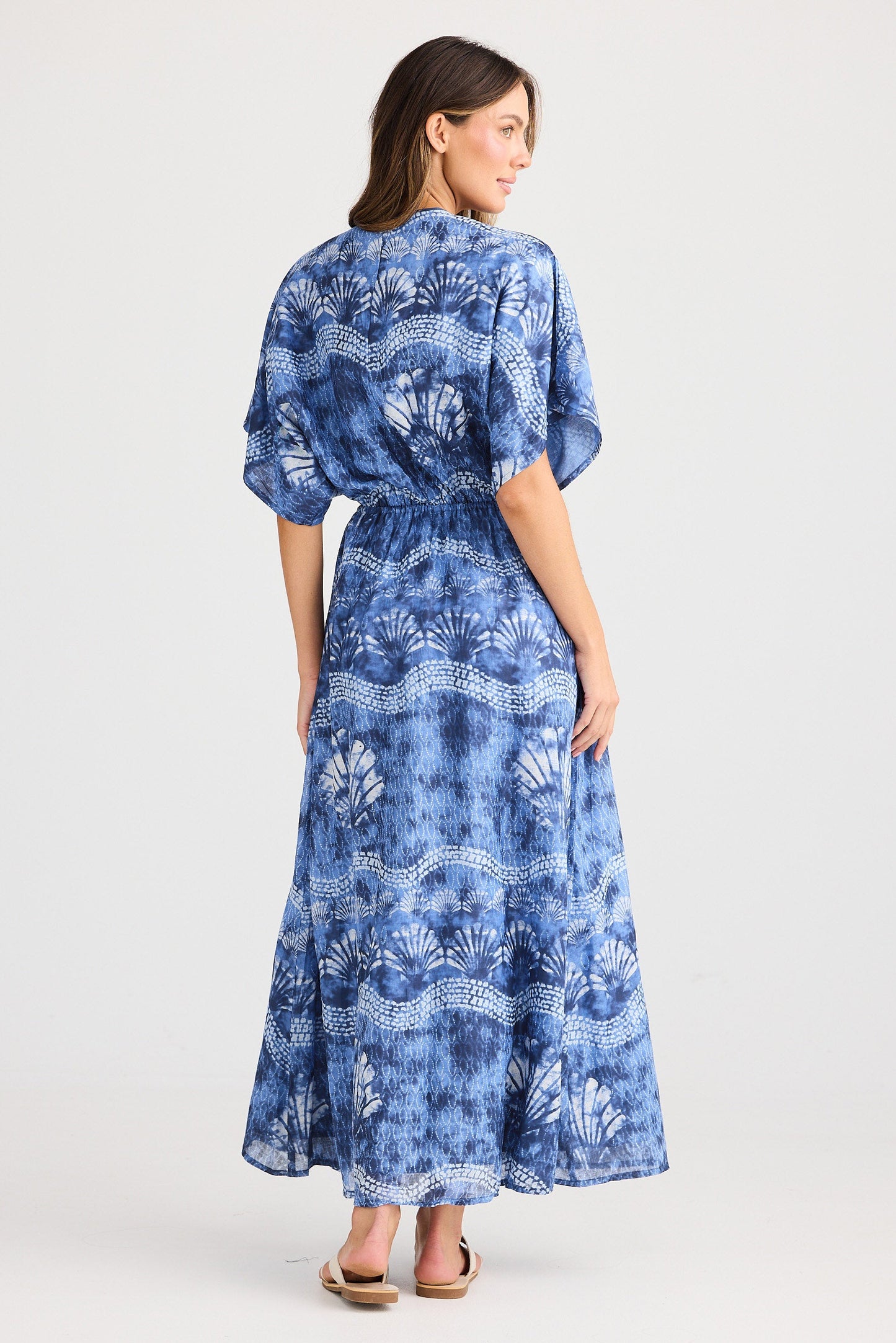 Woman wearing a blue patterned dress on a white background