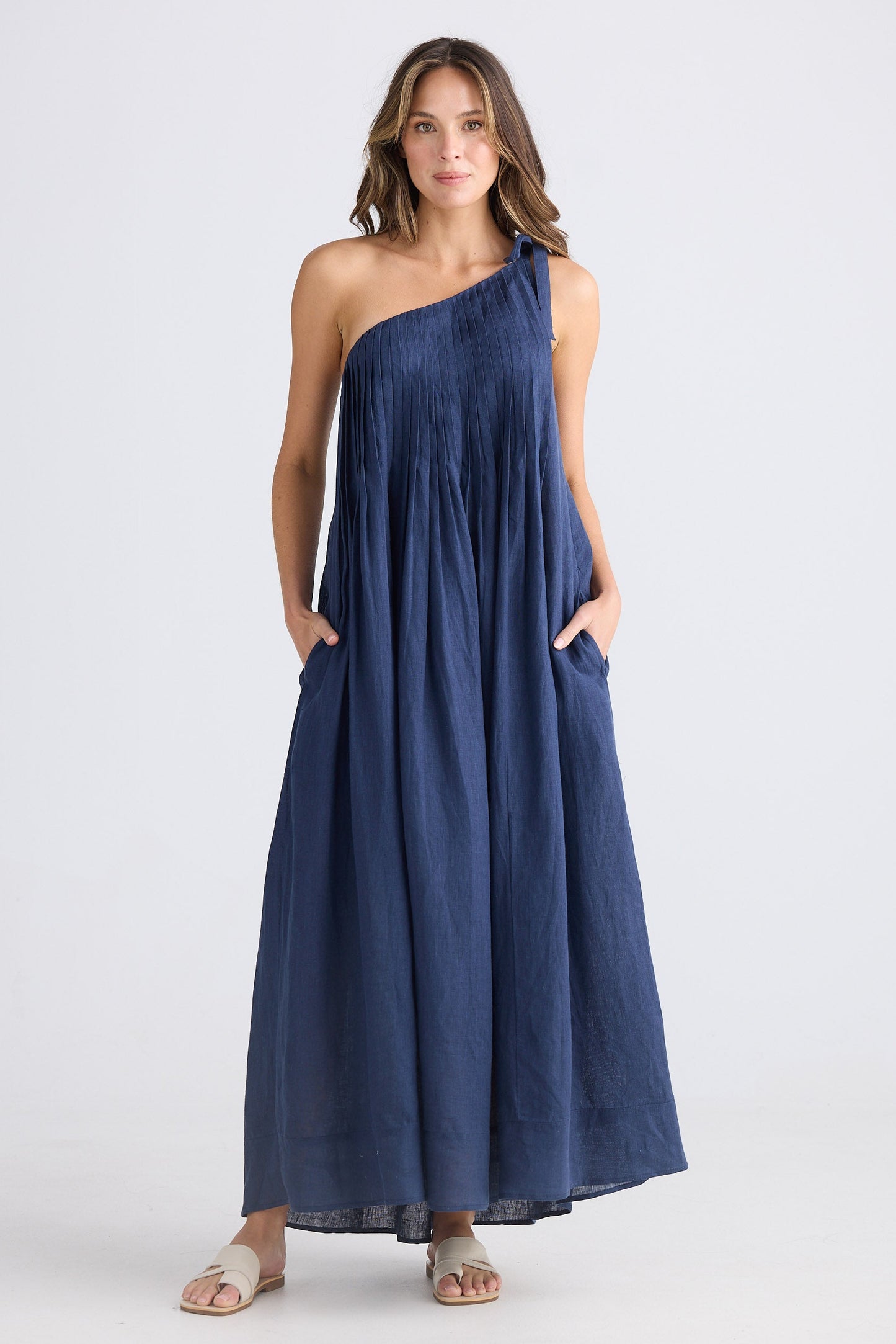 Female wearing one shoulder maxi dress in navy on white background