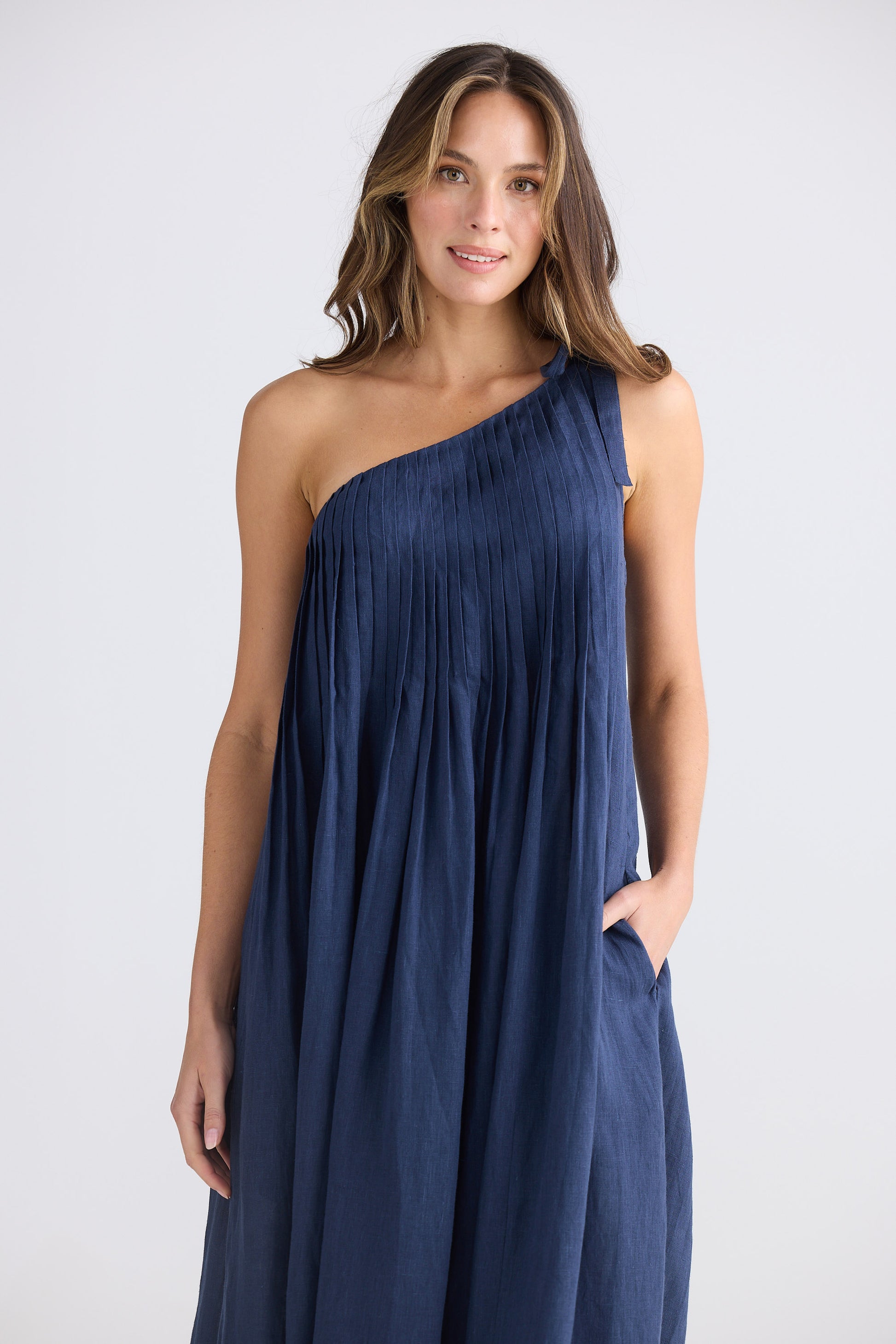 Female wearing one shoulder maxi dress in navy on white background