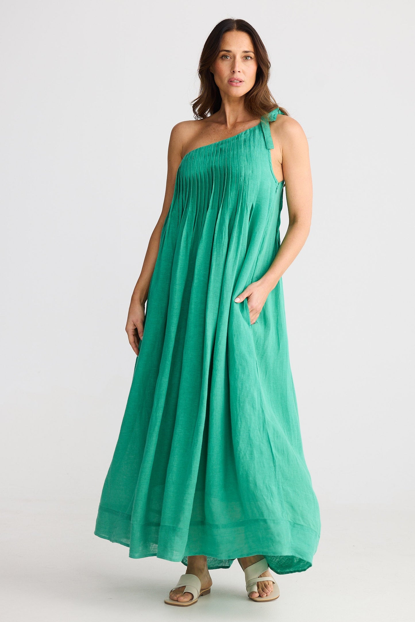 Woman wearing one shoulder green maxi dress on white background