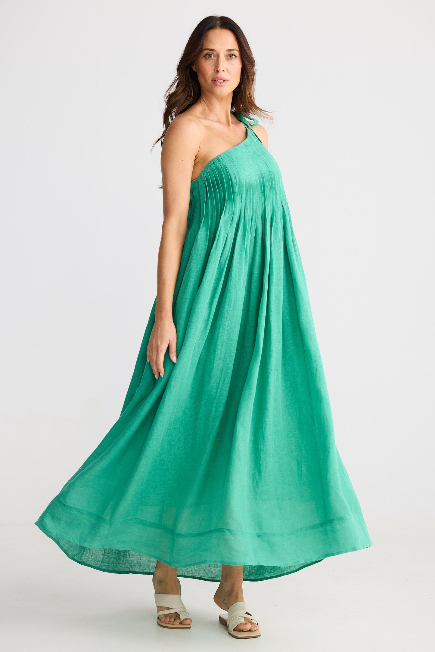 Woman wearing one shoulder green maxi dress on white background