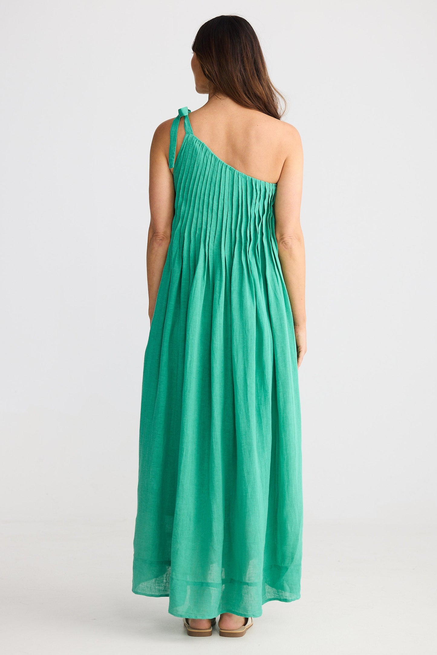 Woman wearing one shoulder green maxi dress on white background
