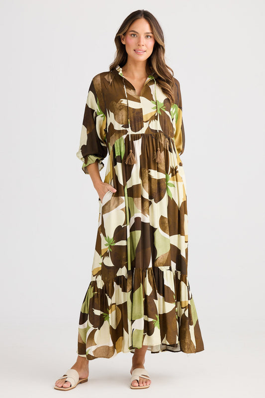 Woman wearing a long, patterned dress on a white background