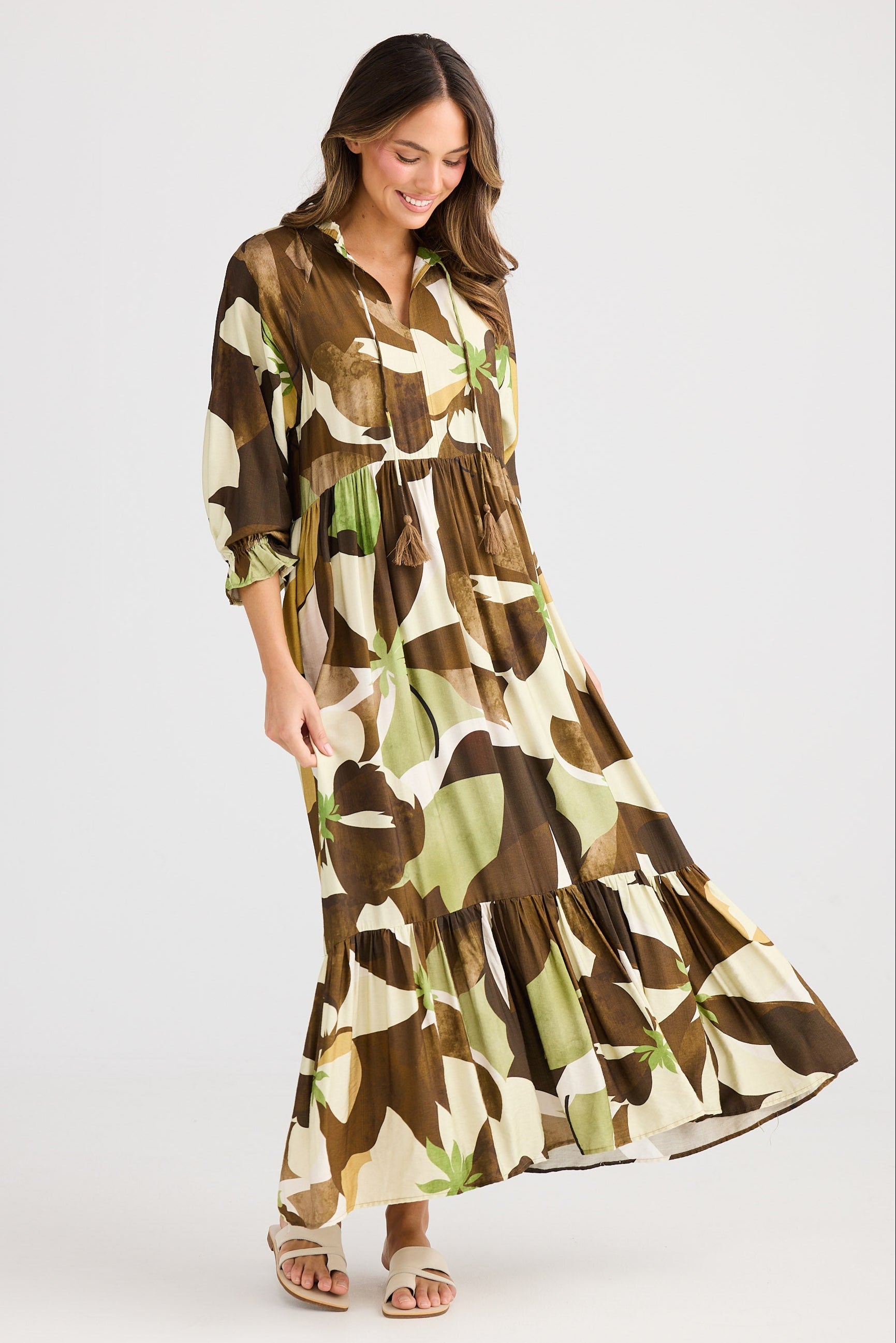 Woman wearing a long, patterned dress on a white background