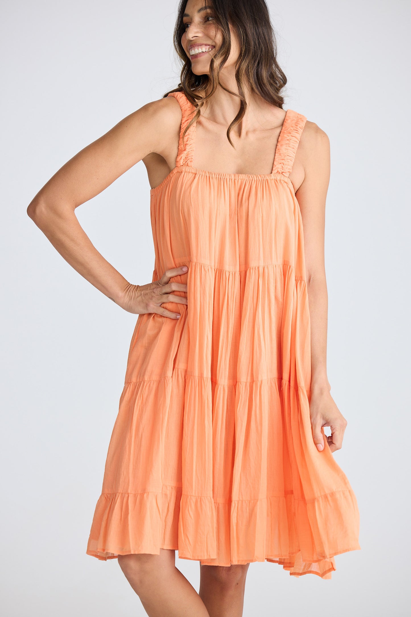 Woman wearing an orange dress against a white background