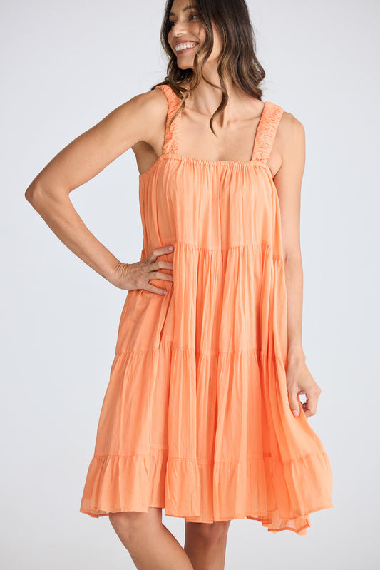 Woman wearing an orange dress against a white background