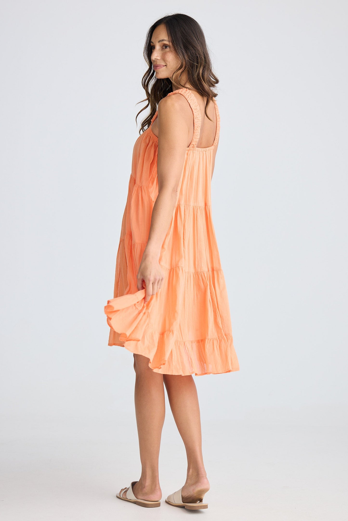 Woman wearing an orange dress on a white background