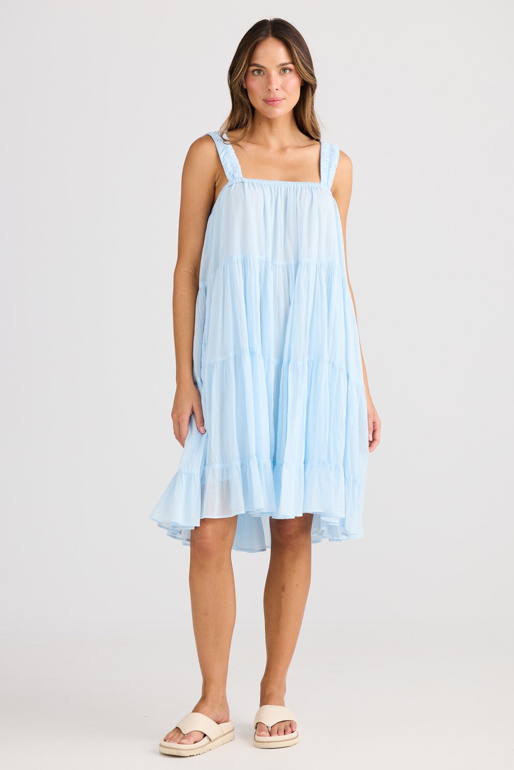Woman wearing a light blue dress on a white background