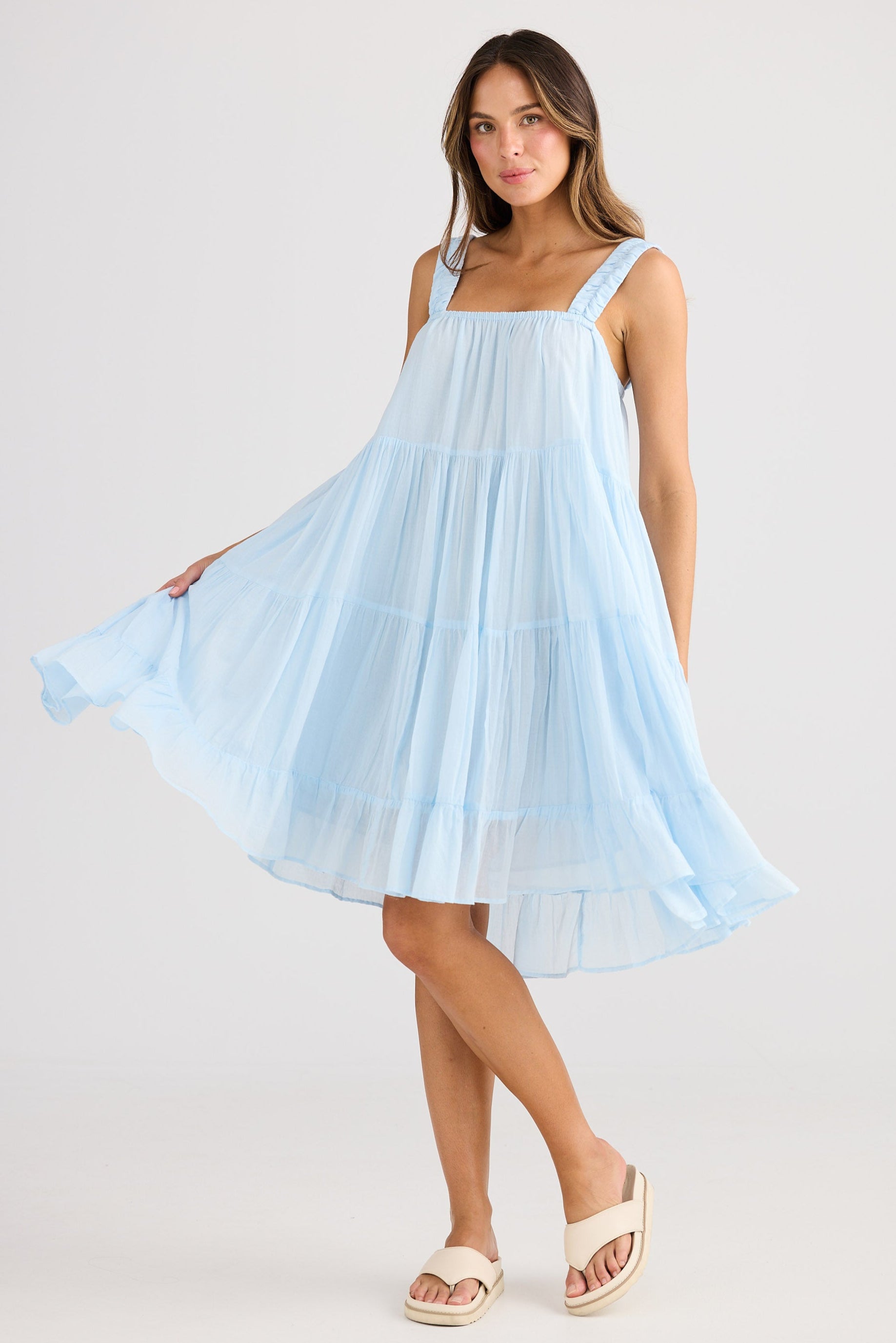 Woman wearing a light blue dress on a white background