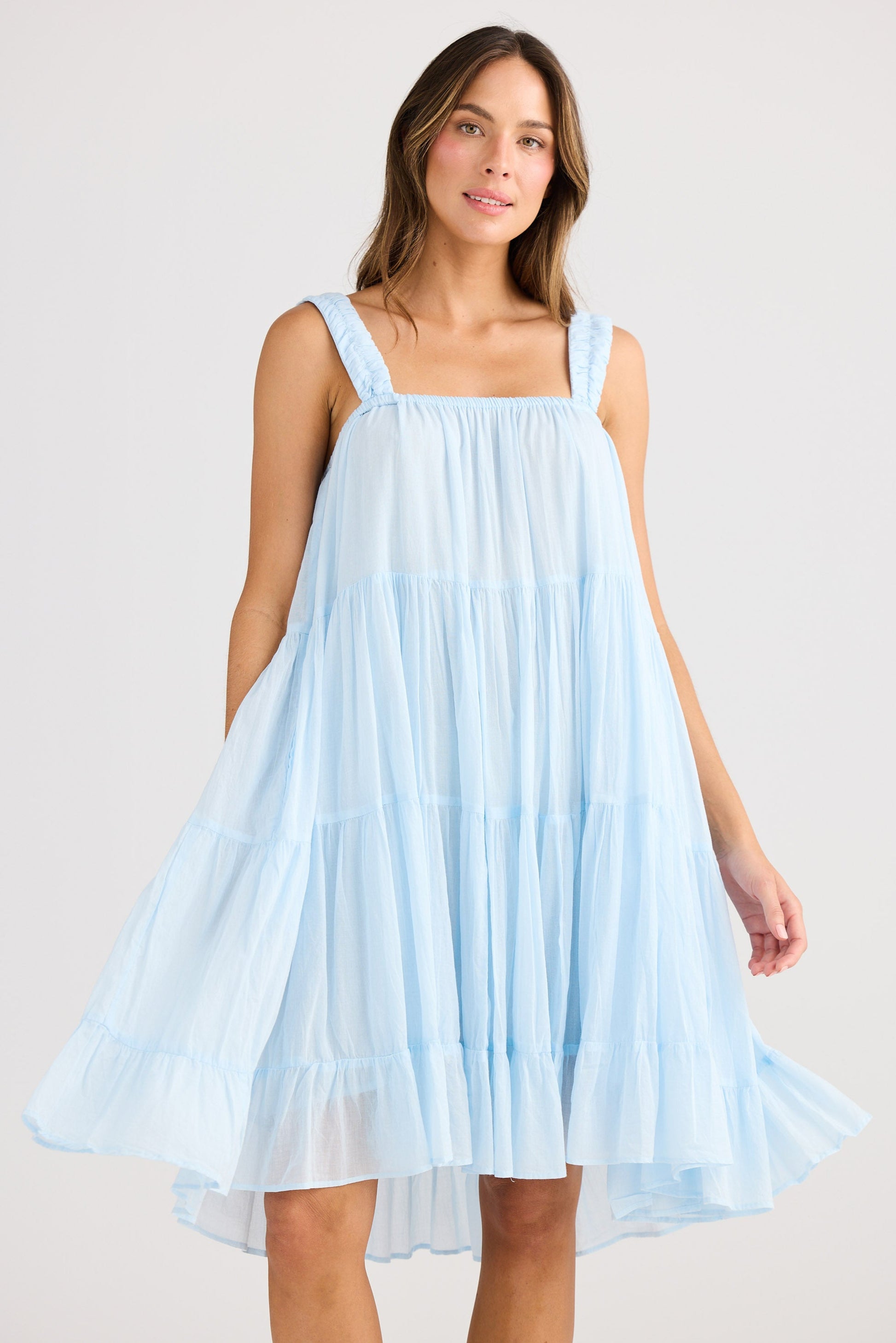Woman wearing a light blue dress against a plain background