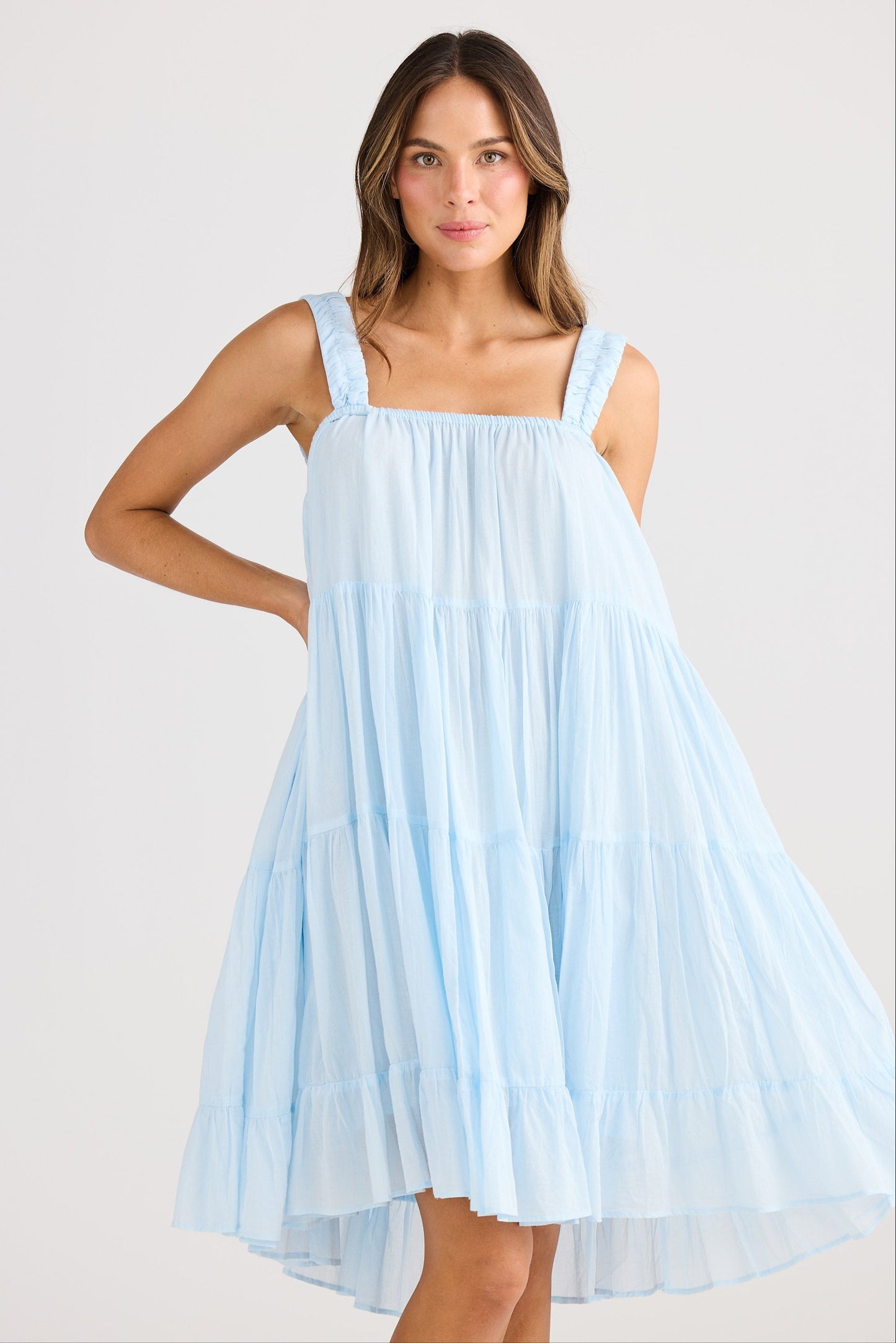 Woman wearing a light blue dress against a white background