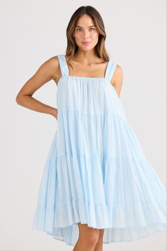 Woman wearing a light blue dress against a white background