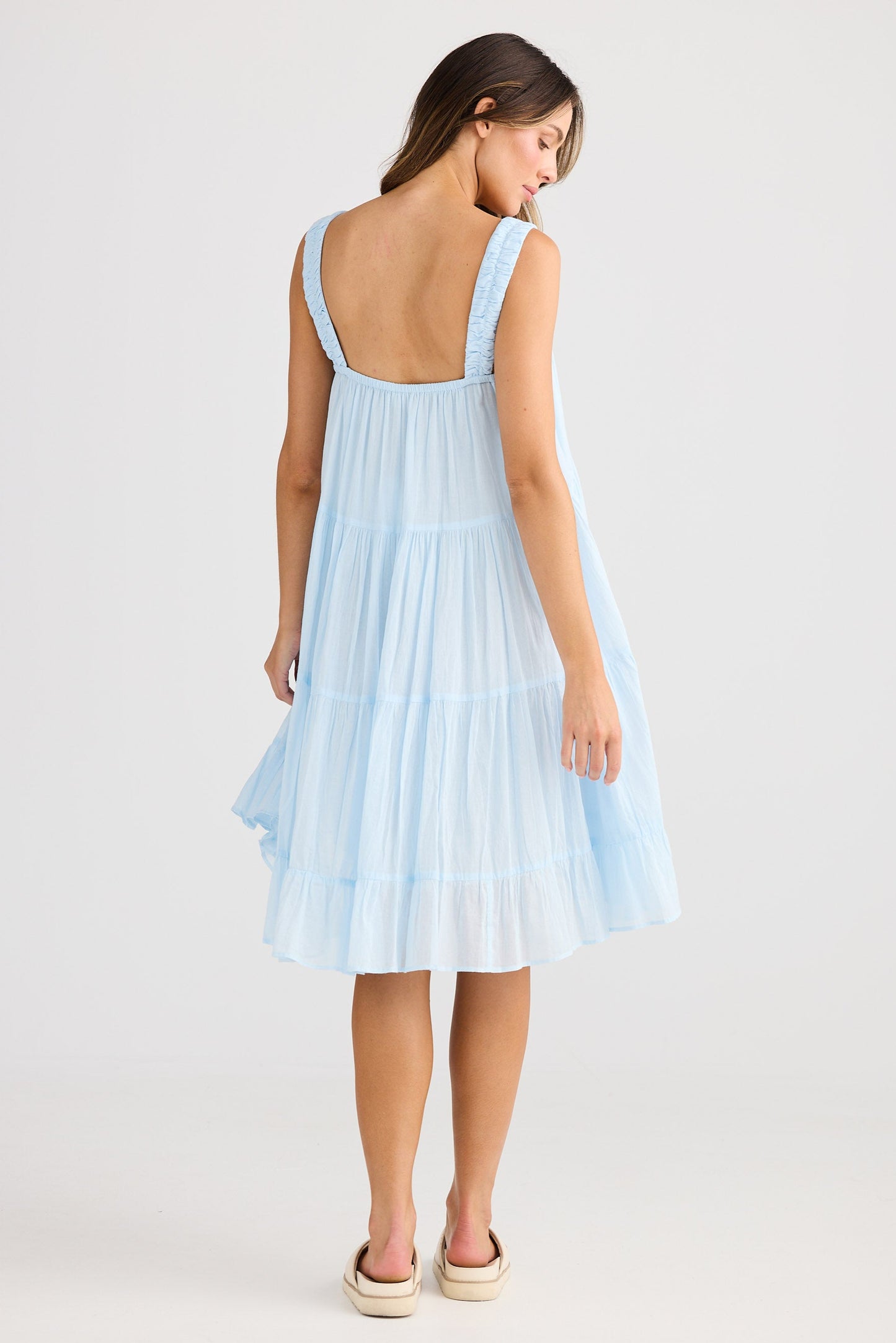 Woman wearing a light blue dress on a white background
