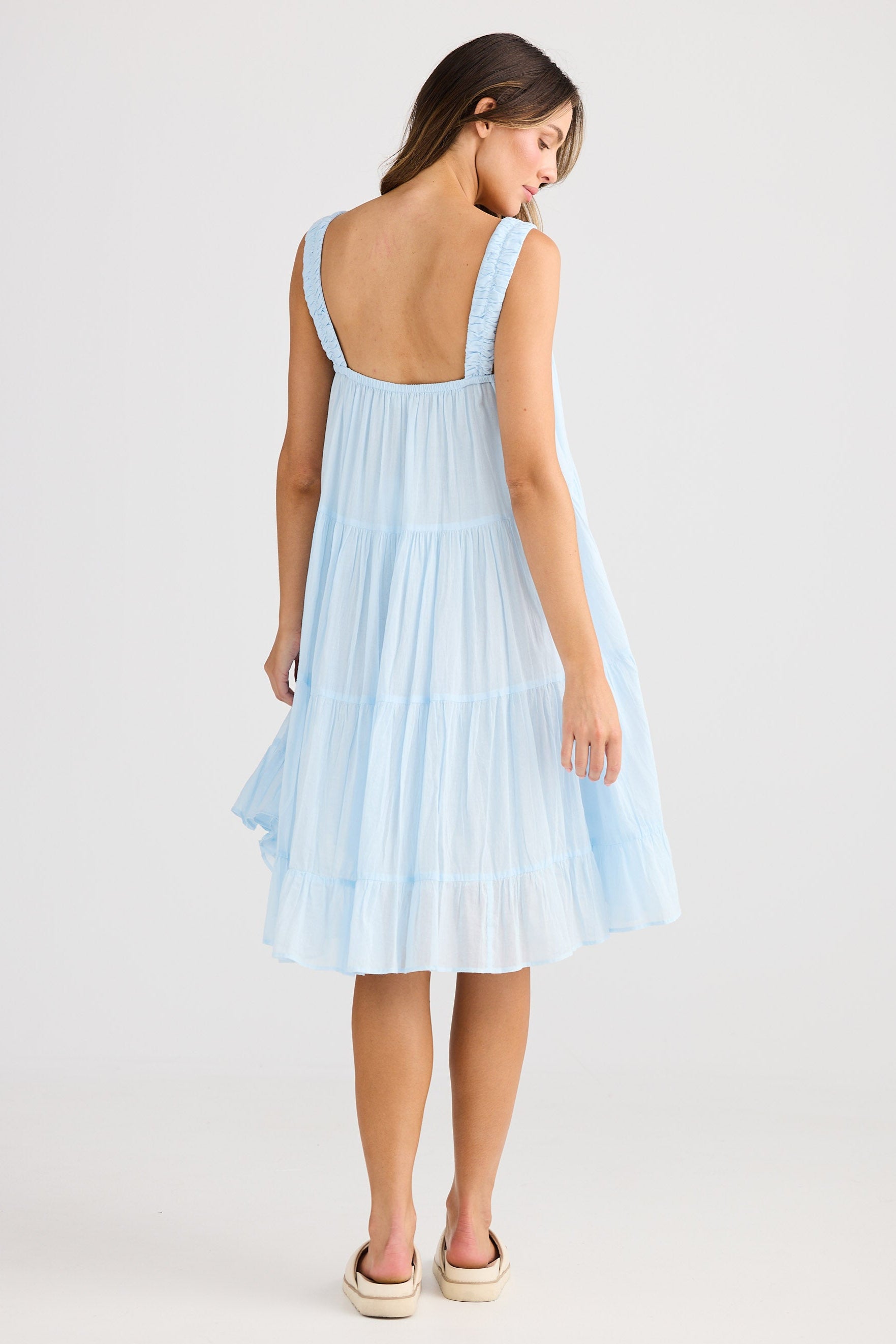 Woman wearing a light blue dress on a white background