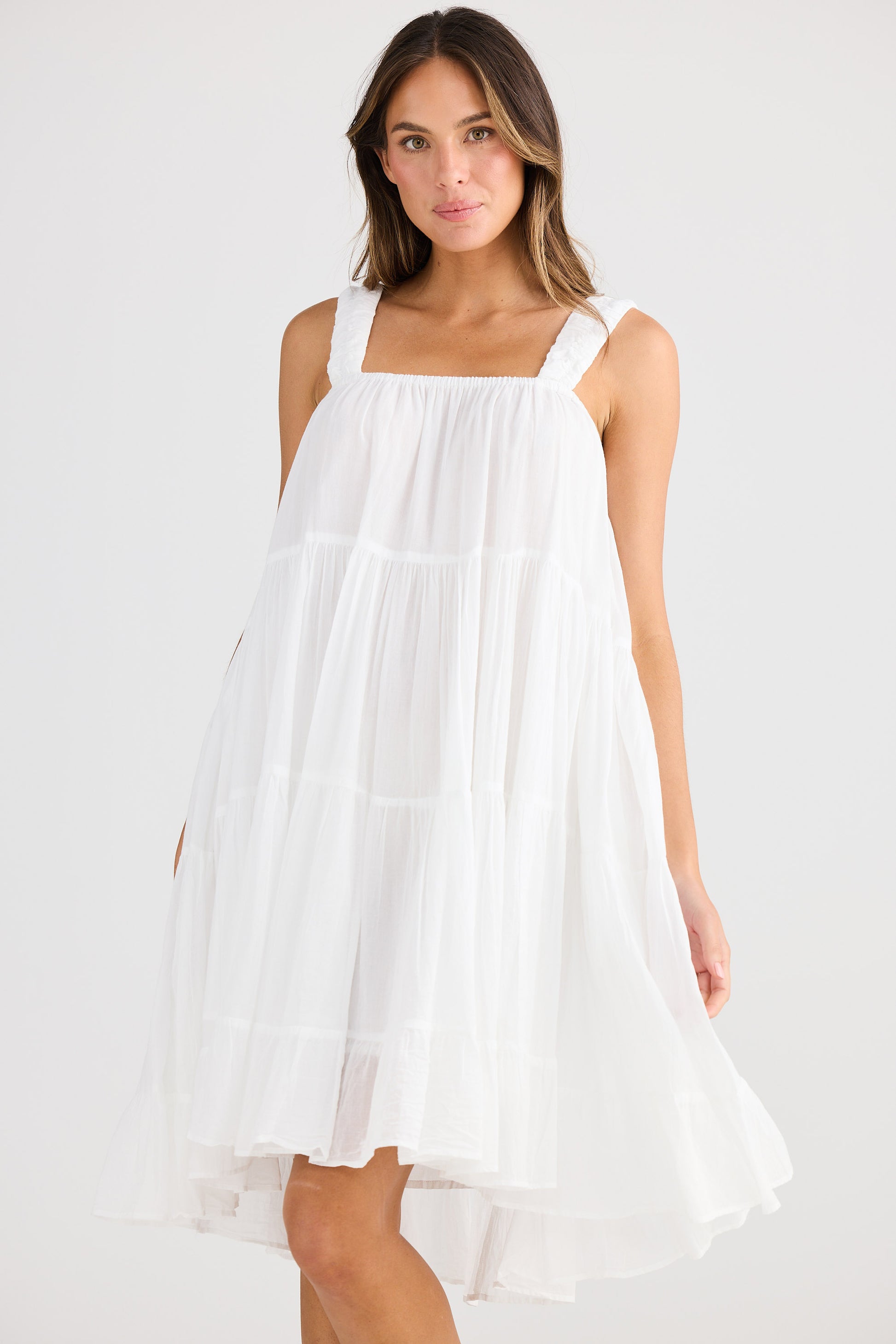 Woman wearing a white dress against a white background