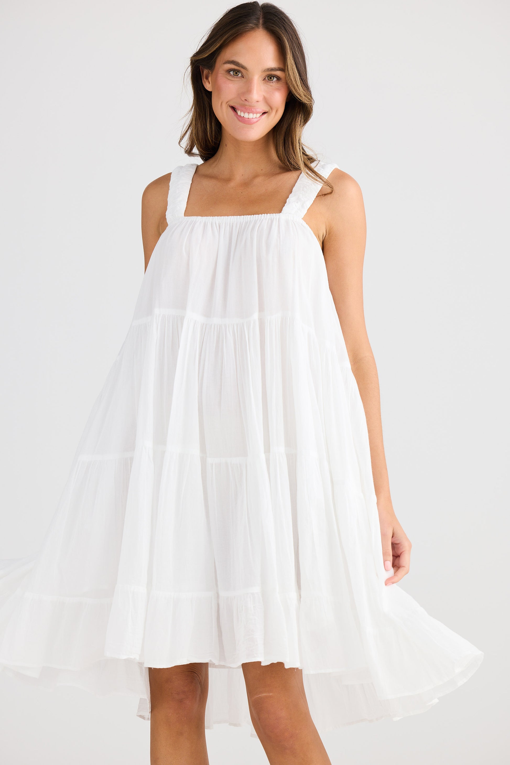 Woman wearing a white dress on a plain background