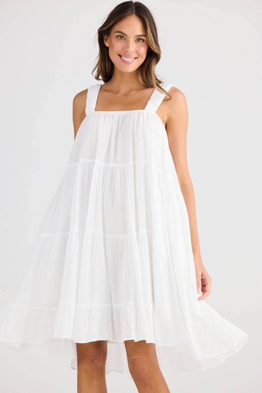 Woman wearing a white dress on a plain background