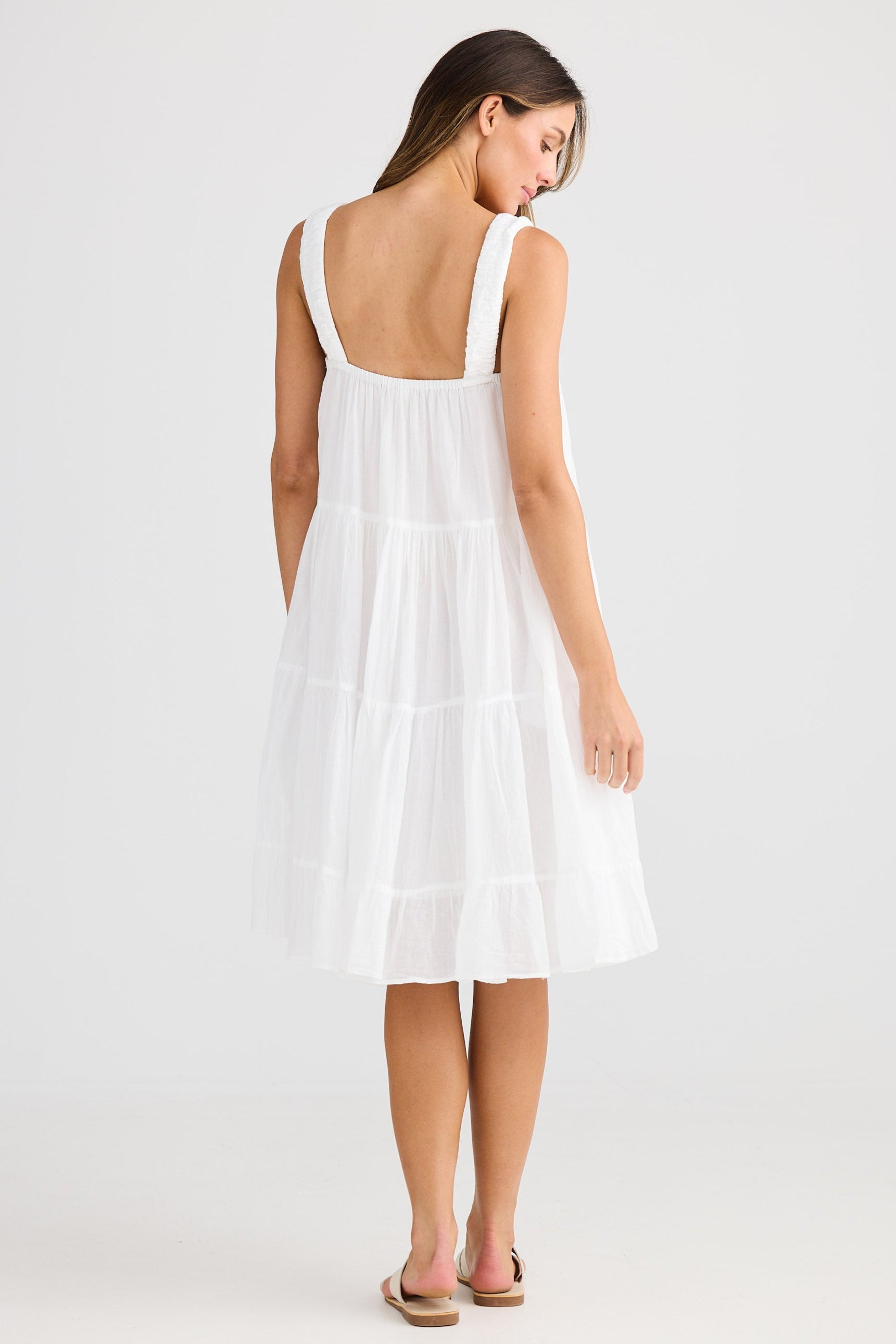 Woman wearing a white dress on a plain background